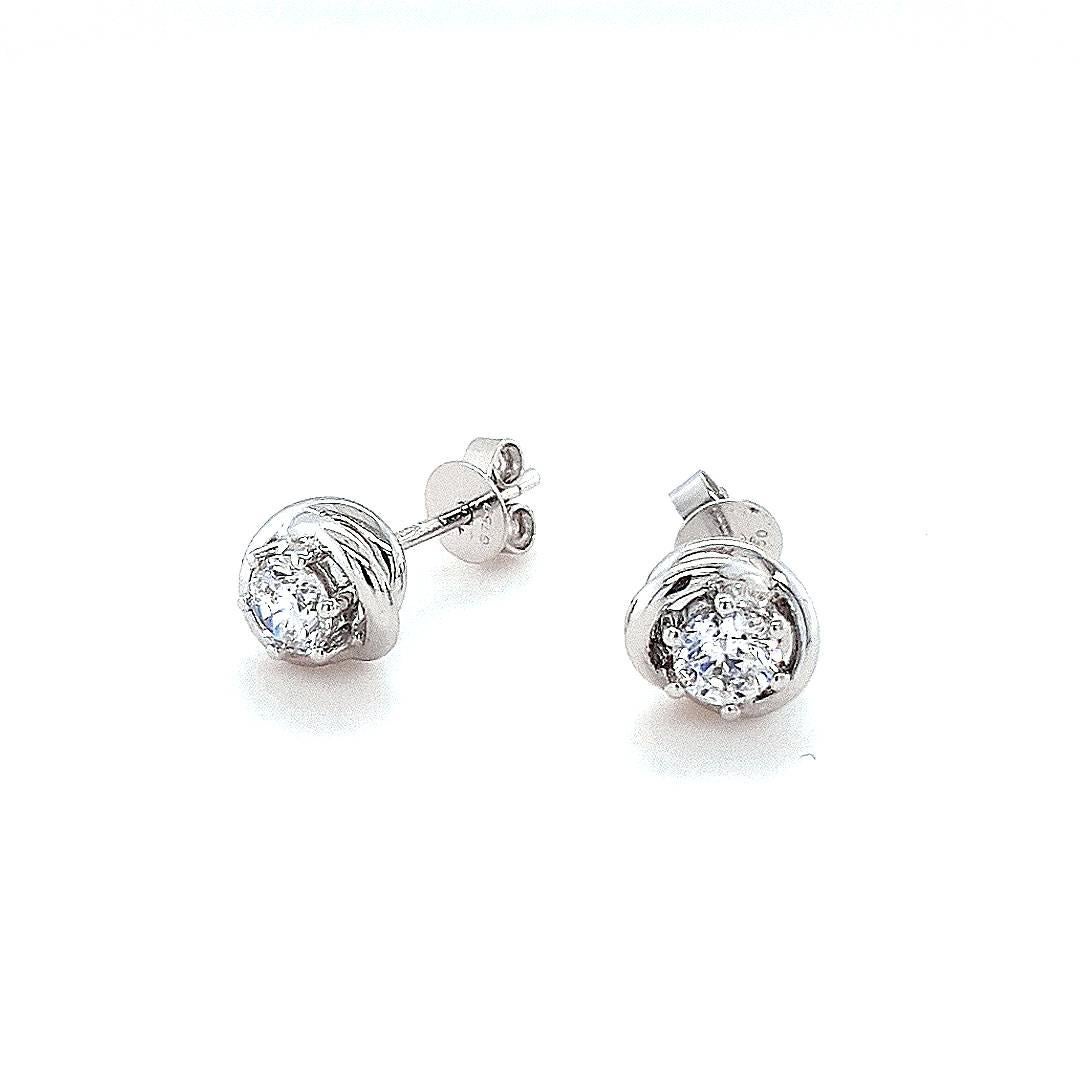 The exquisite Aurora Stud Earrings each showcase a stunning 0.25ct diamond, elegantly framed by twisted halos of 18ct white gold. Adorn yourself in the celestial allure of these finely crafted earrings, designed to elevate your style with a touch of