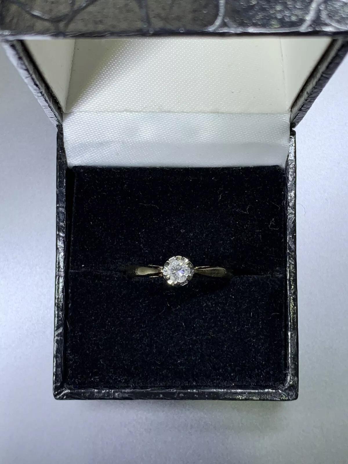 This antique solitaire engagement ring is a stunning piece of jewellery, crafted from 9ct yellow gold and featuring a beautiful round-cut natural white diamond as the main stone with a total carat weight of 0.25. The diamond is set in a classic
