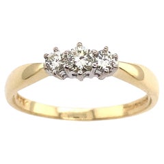0,25ct  Anello con diamante classico a trilogia in oro giallo e bianco 18 ct.