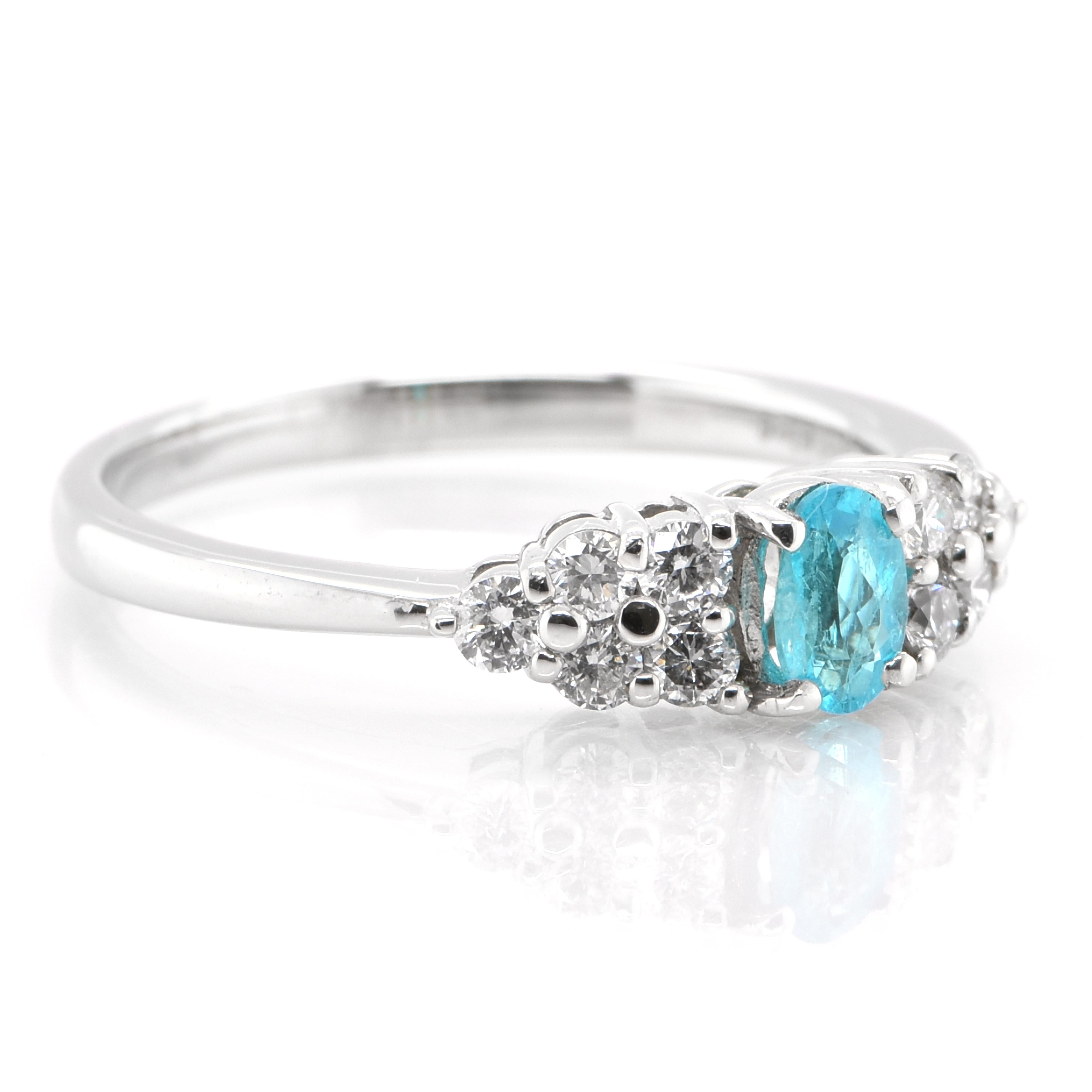 An elegant engagement ring showcasing a 0.26 Carat oval-shaped, natural Brazilian Paraiba Tourmaline and 0.31 carat of Diamond Accents set in Platinum. The center Paraiba Tourmaline comes with a GIA report confirming its Brazilian origin. The center