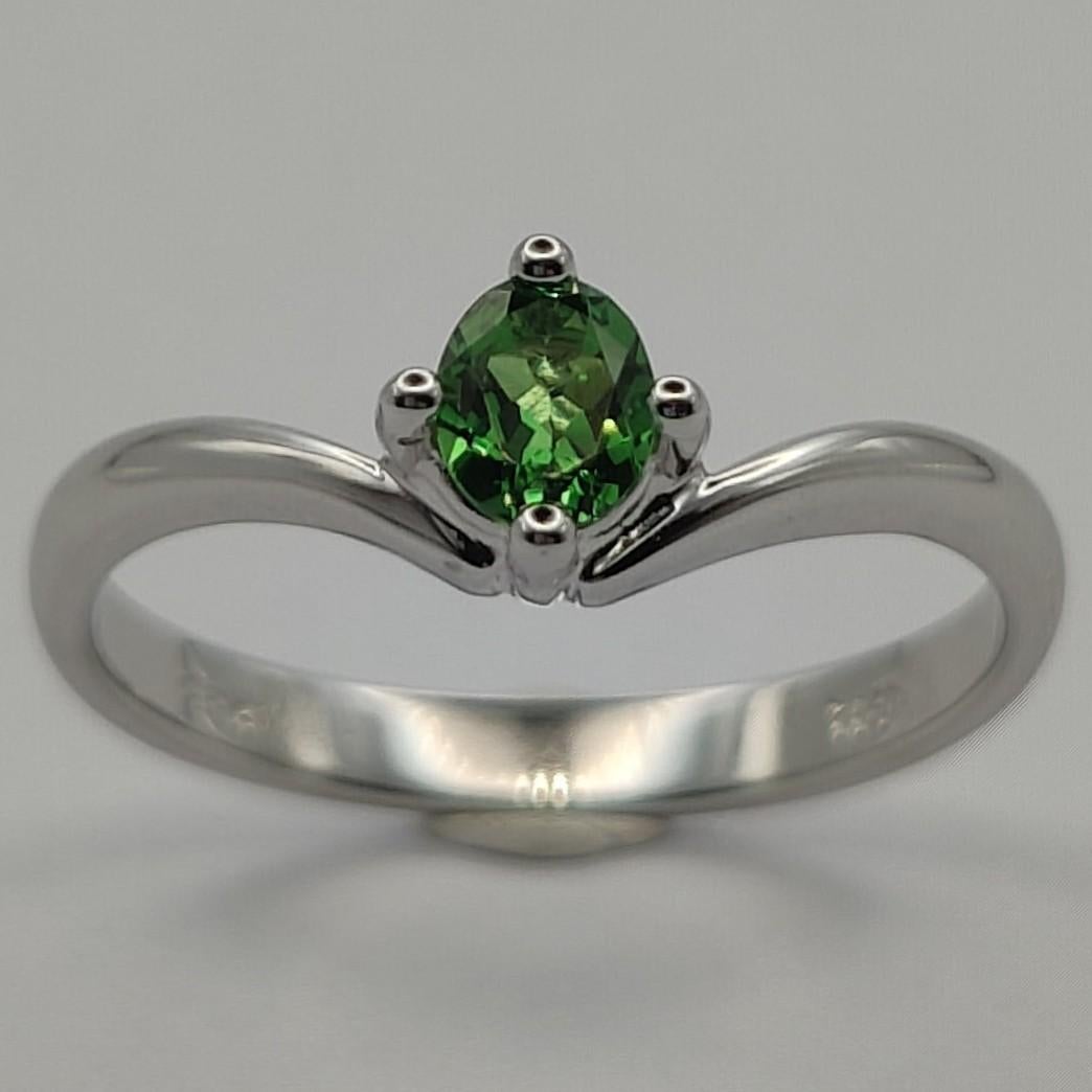 This beautiful emerald solitaire ring is a truly stunning piece of jewelry that is sure to turn heads. The green main stone, an oval cut emerald, is a unique and eye-catching choice that is perfect for anyone looking for something a little