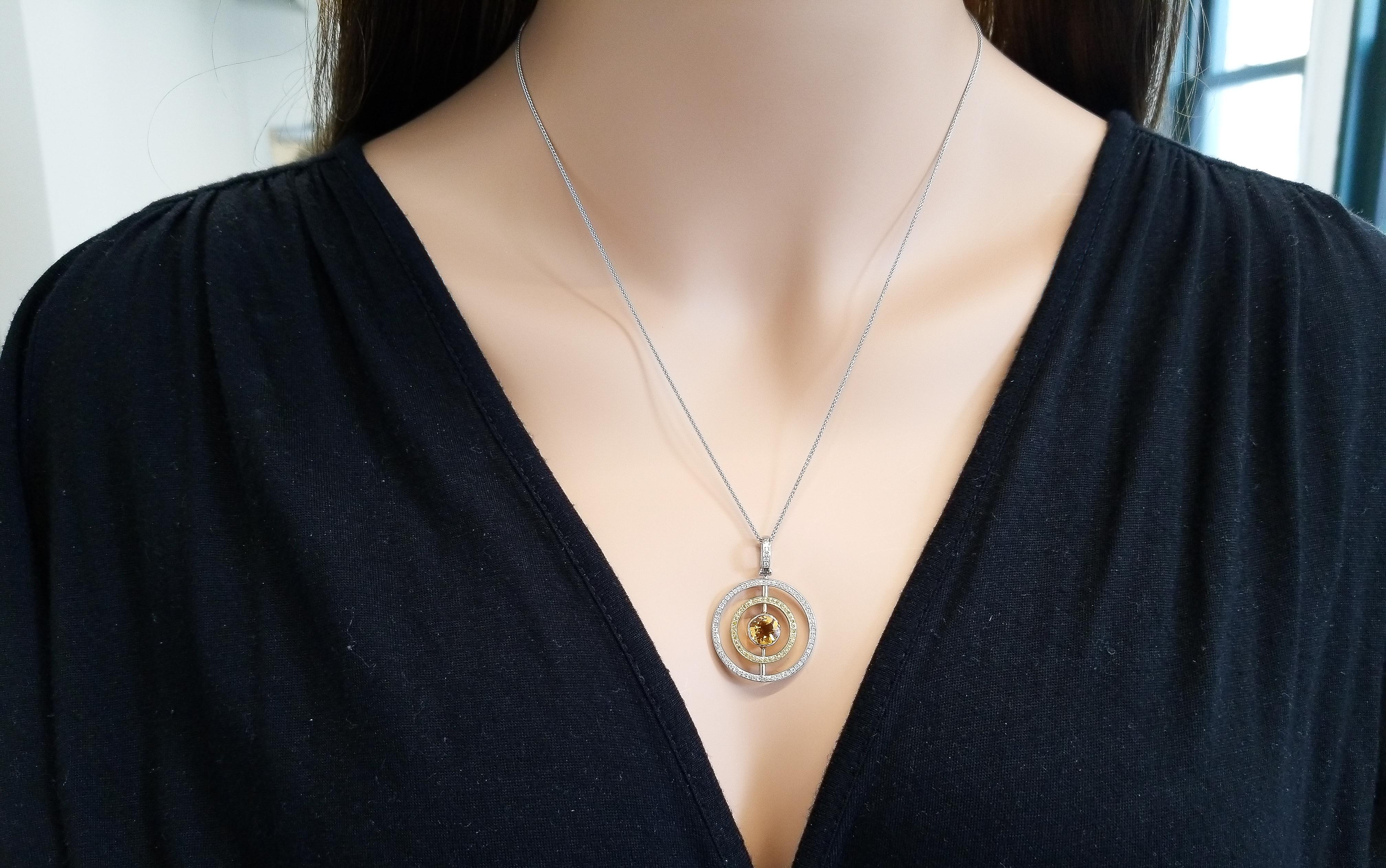 Designed in 18 karat two-tone gold, this spectacular eternity concentric circle pendant features a round brilliant cut intense sunny yellow citrine bezel set in the center, creating a modern style. A total of 0.27 carat round brilliant white