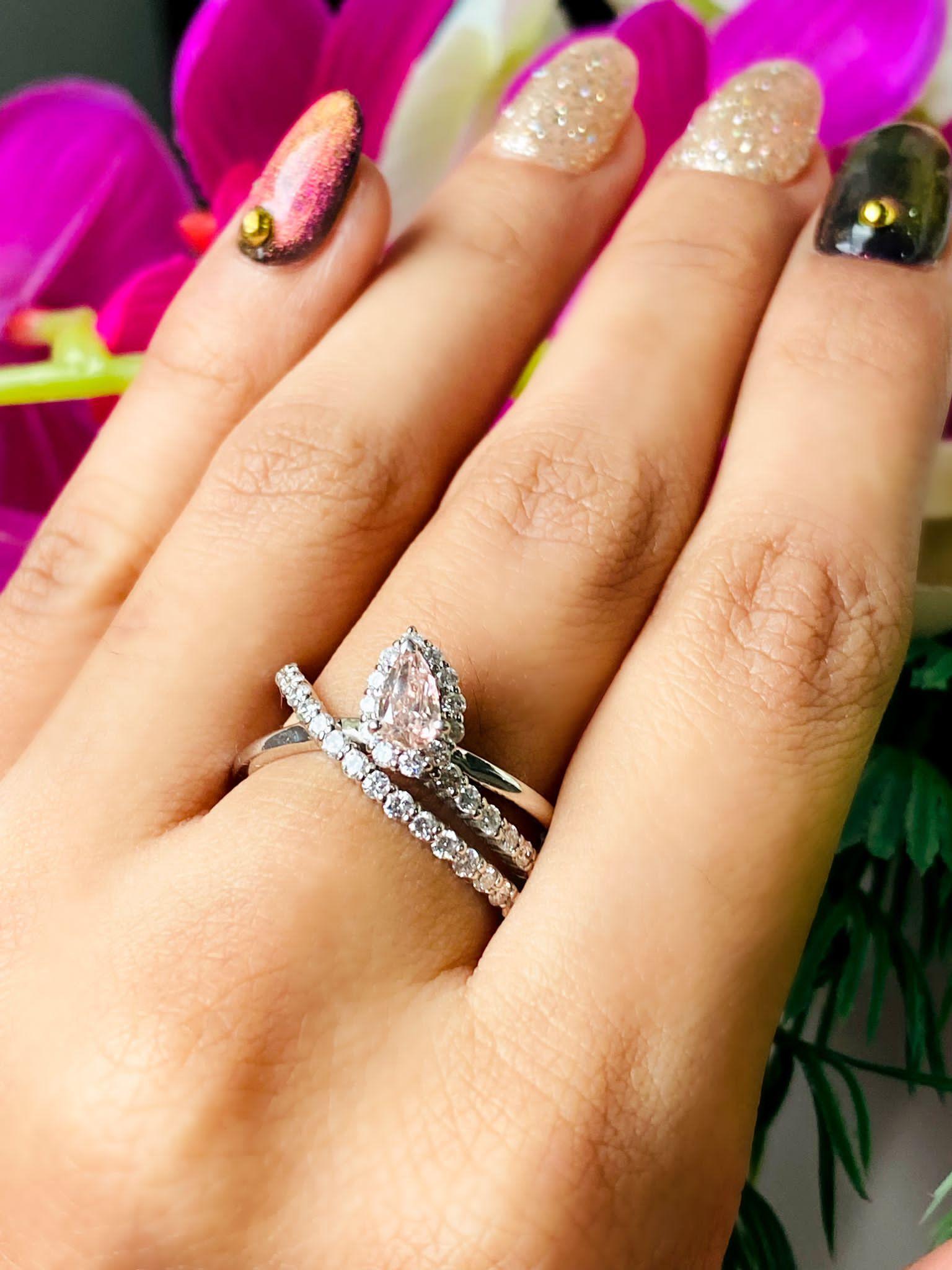 18kt white gold ring with diamonds
  
  Gold colour & karat: White gold 18kt
  Weight: 7.805 grams
  
  Set with-
  Stone type: Diamonds
  Shape: Pear
  Carat: 0.272
  Colour: Very Light Pink  
  Clarity: SI1
  
  Surrounding Stones: Diamonds
 1)