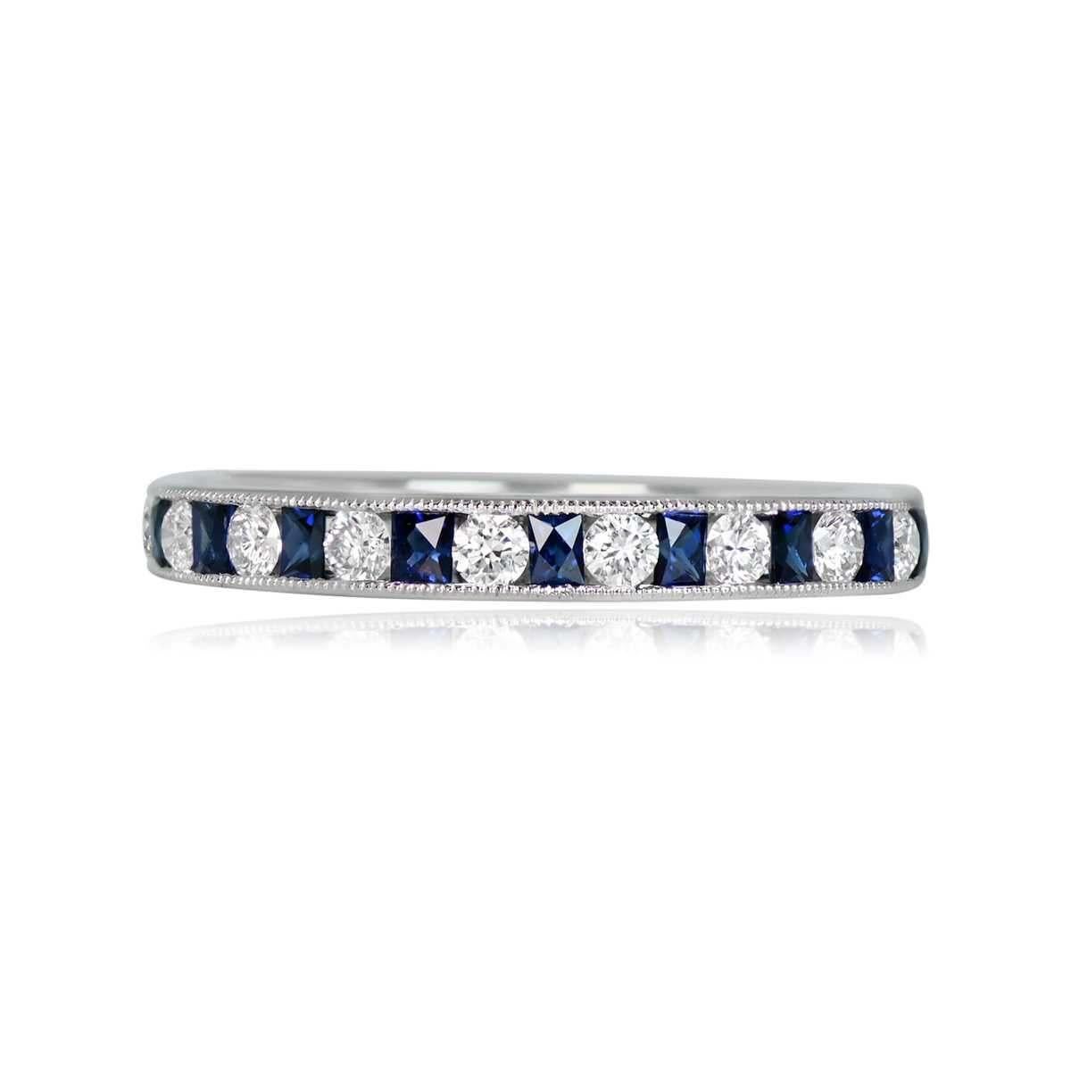 An exquisite half-eternity band crafted in platinum, featuring natural French-cut sapphires and round brilliant cut diamonds in an artful channel setting adorned with delicate milgrain detailing. The diamonds have a total carat weight of 0.27