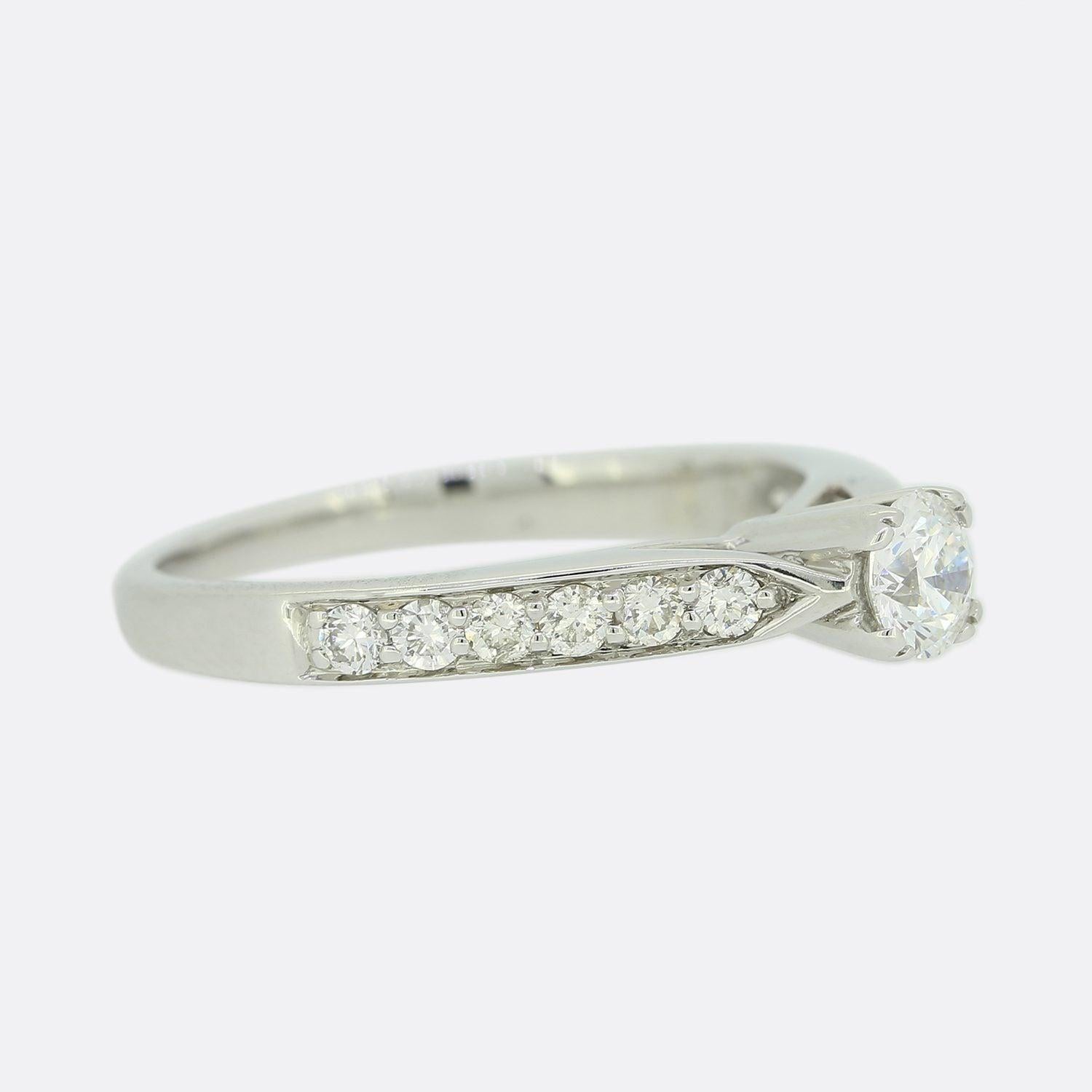 Dies ist ein Solitär-Verlobungsring aus 18 Karat Weißgold. Der Ring ist mit einem einzelnen, erhabenen runden Brillanten von 0,28 Karat und weiteren 6 Diamanten auf jeder Schulter besetzt.

Zustand: Gebraucht (Sehr gut)
Gewicht: 2.7 Gramm
Größe: M