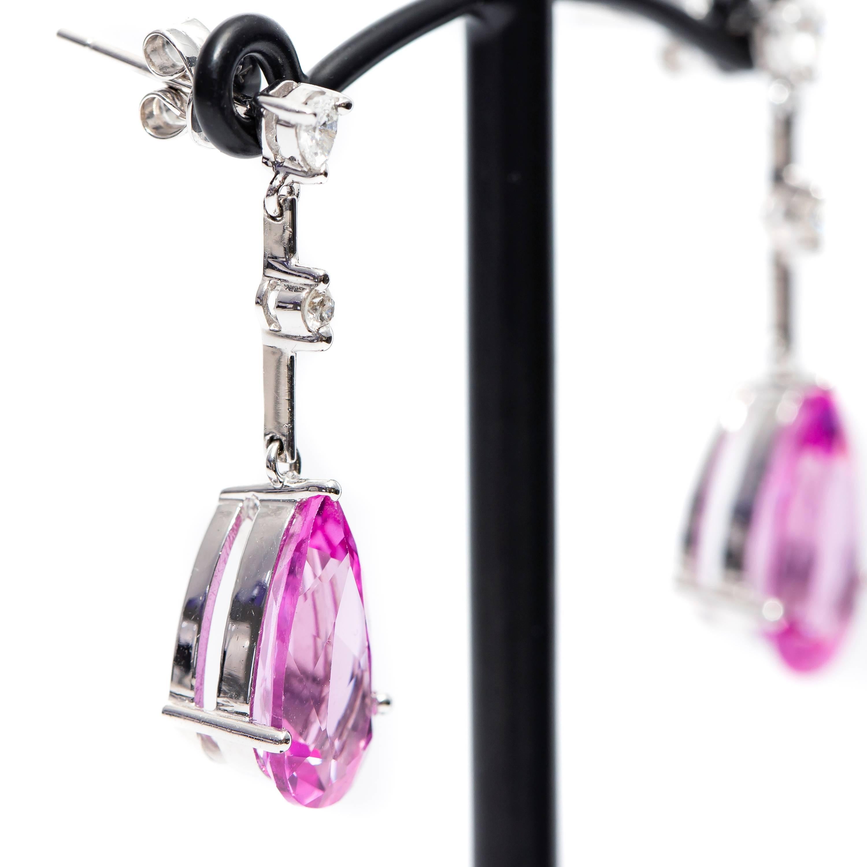 Beautiful Pink Synthetic Corundum,  looks like vibrant pink sapphire 15 mm x 8 mm Drop Earrings featuring 0.28 Carat Pear and Round Diamonds Color H Clarity SI1. Perfect for any occasion set in 18 Karat White Gold, British Hallmarked.
This design