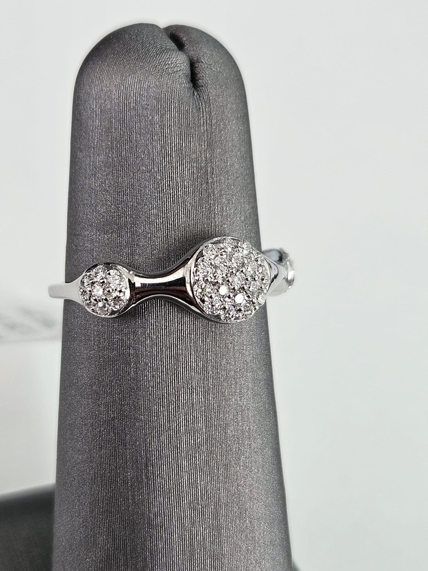 Wir präsentieren einen atemberaubenden Cluster-Ring mit weißen Diamanten, der zeitlose Eleganz und Raffinesse ausstrahlt und ein Gesamtkaratgewicht von 0,28 Karat aufweist. Dieser exquisite Ring zeichnet sich durch drei horizontal ausgerichtete