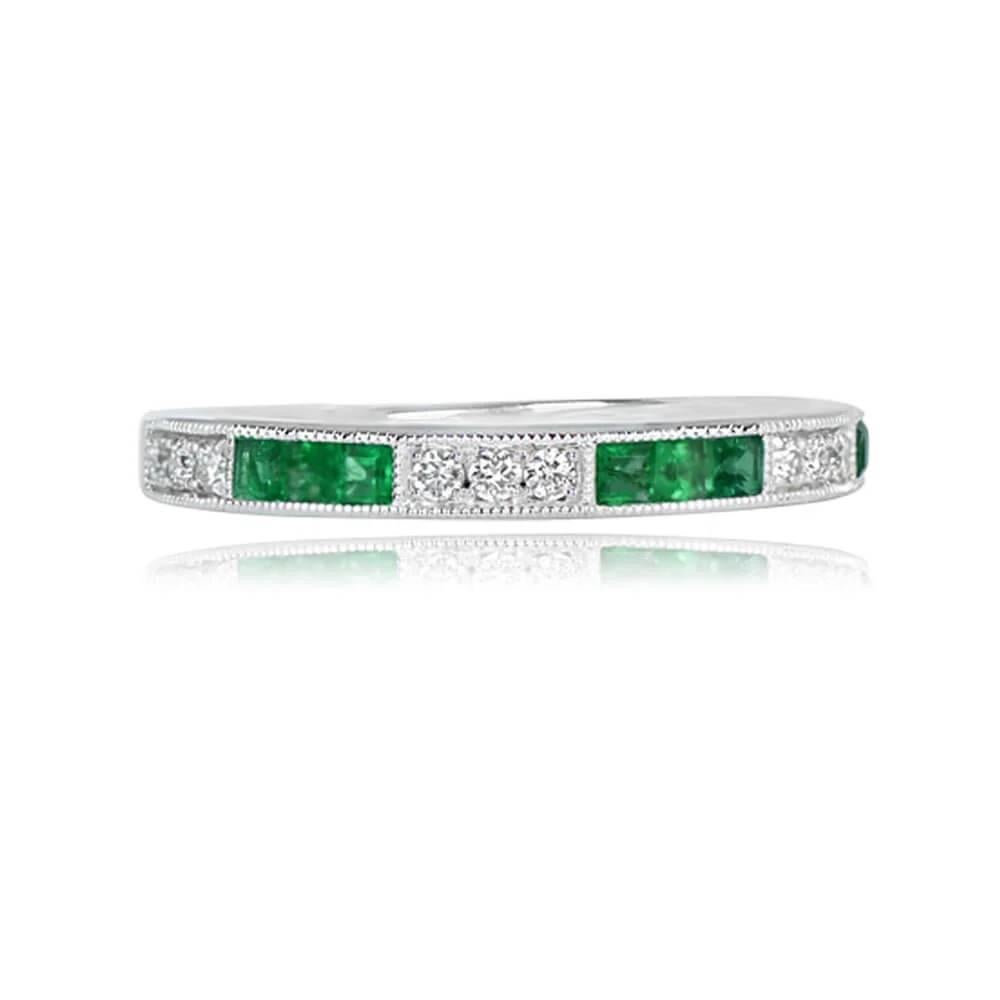 A captivating half-eternity band crafted in platinum, featuring calibre cut natural emeralds weighing a total of 0.28 carats and round brilliant cut diamonds with a combined weight of 0.14 carats. The emeralds are elegantly channel-set, while the
