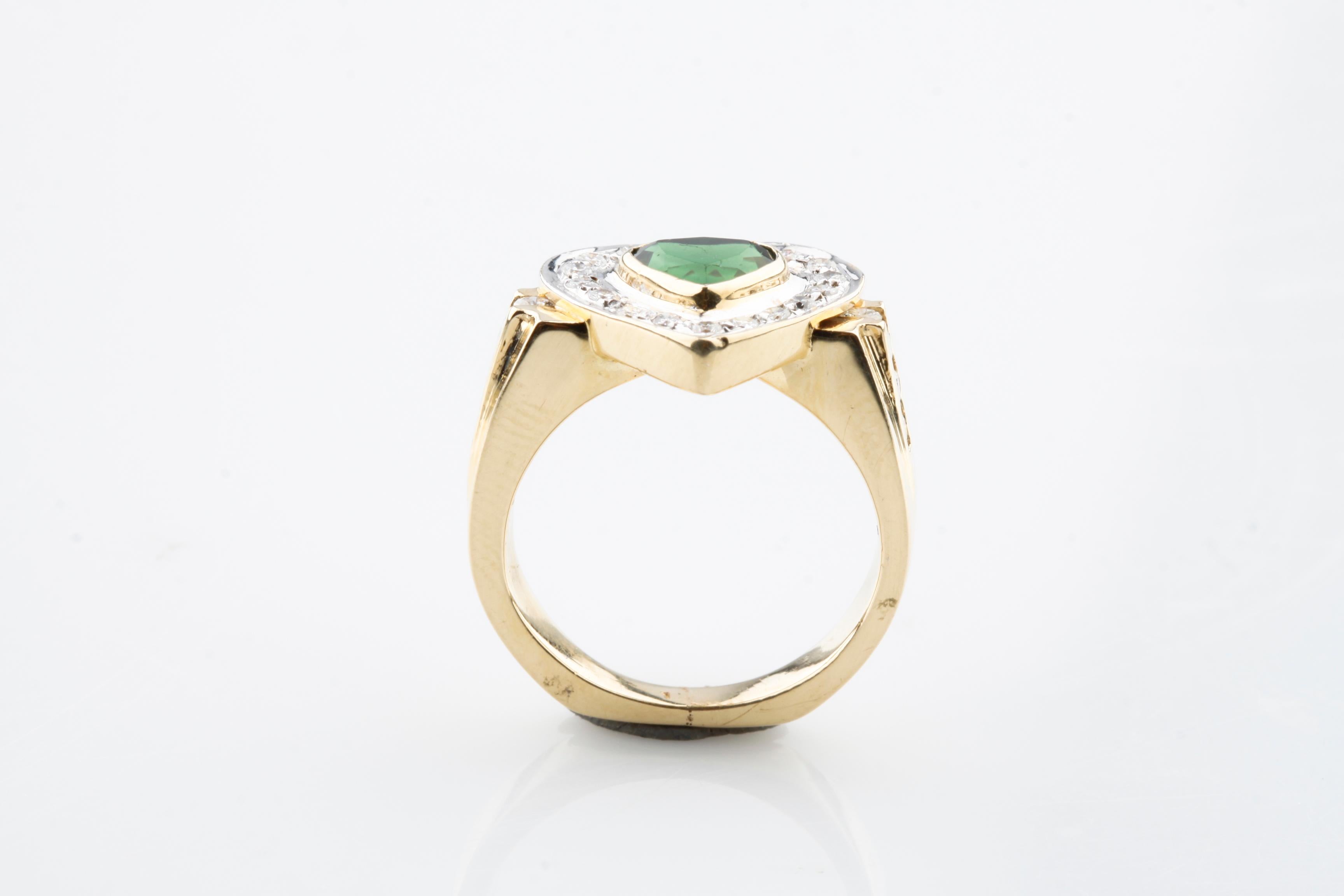 One Electronically tested 14k yellow gold ladies cast green tourmaline and diamond ring. Condition is good. Bright polish finish with rhodium accents.
Containing:
One Bezel Set Heart Mixed Cut Natural Green Tourmaline 
Measuring 6.60 x 5.90 x 4.00