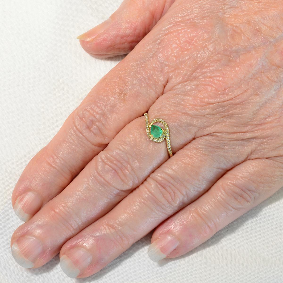 Unique to EK Designs this eye catching diamond ring features a stunning natural emerald embellished with bright microset diamonds set in solid 9K yellow gold. The 0.30 carat natural pear cut emerald is secured by 3 claws in an open back setting to