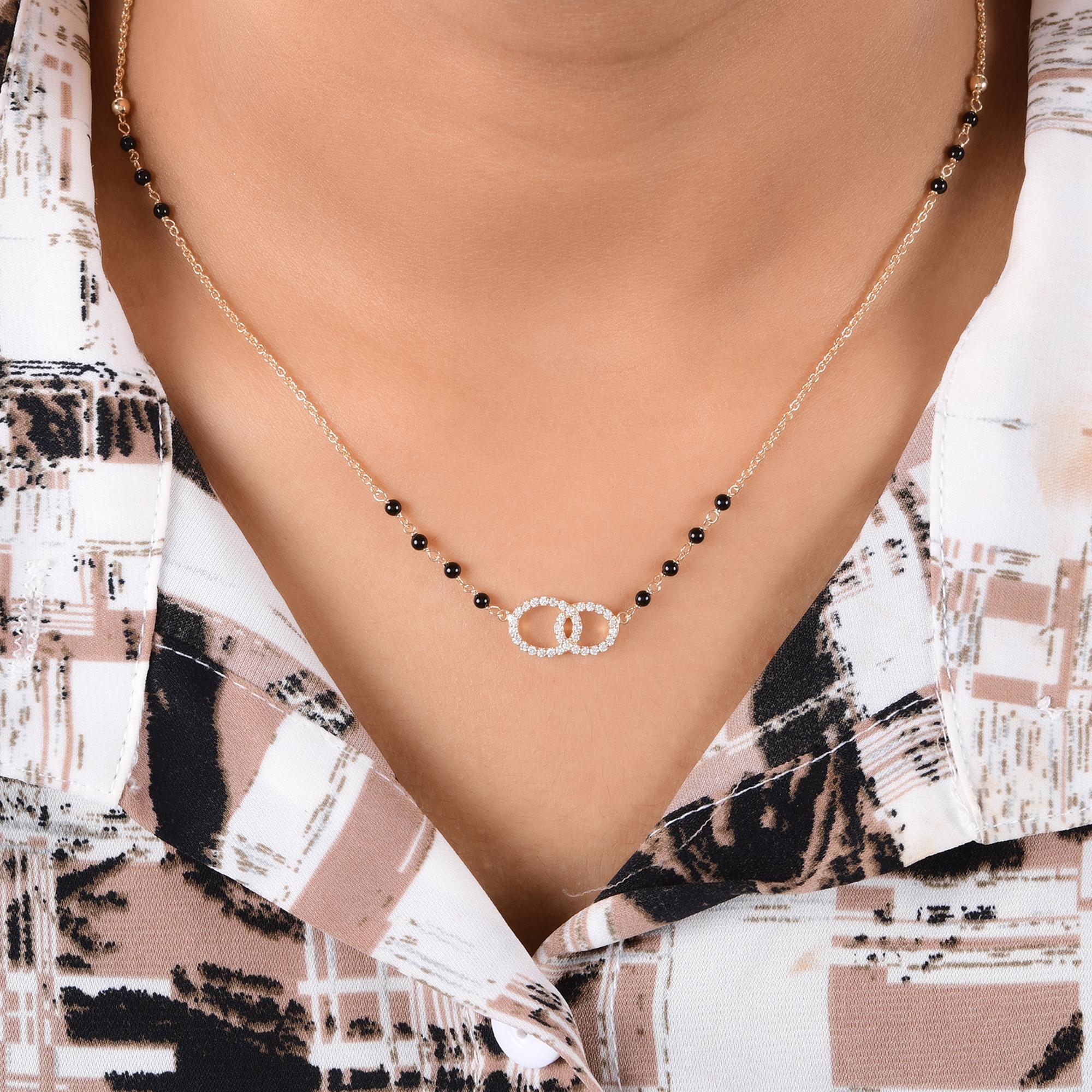 0.30Ct Black Bead Diamond Pendant Mangalsutra for Women 14k Yellow Gold
Cette pièce magnifiquement travaillée présente deux motifs circulaires reliés entre eux, représentant le lien indéfectible entre deux âmes. Le design est associé à une délicate