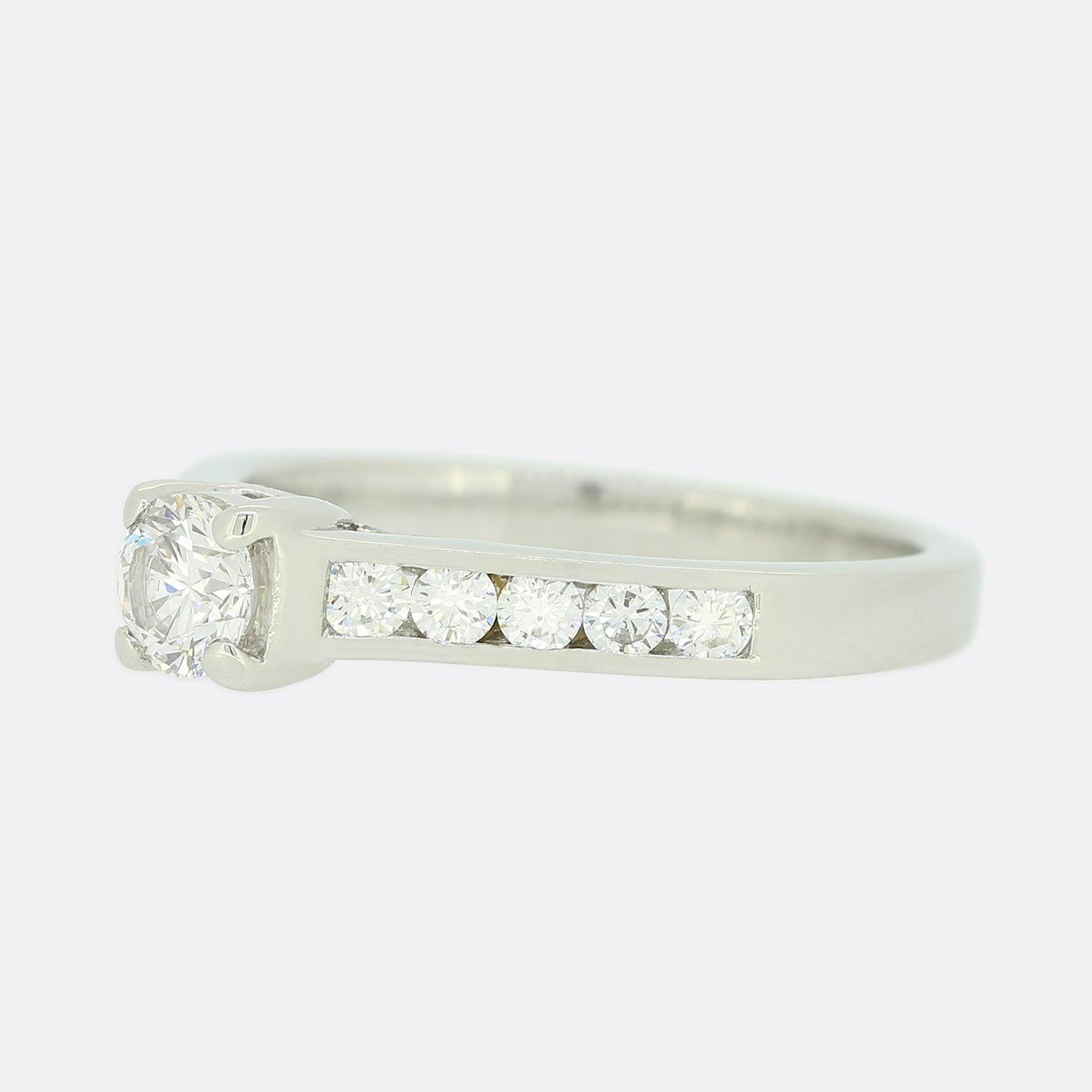Dies ist ein Single Stone GIA-zertifizierter Diamant-Verlobungsring. Im Mittelpunkt dieses Rings steht ein runder Diamant im Brillantschliff, der in einer vierfachen Krappenfassung aus Platin mit kanalgefassten Diamantschultern gefasst