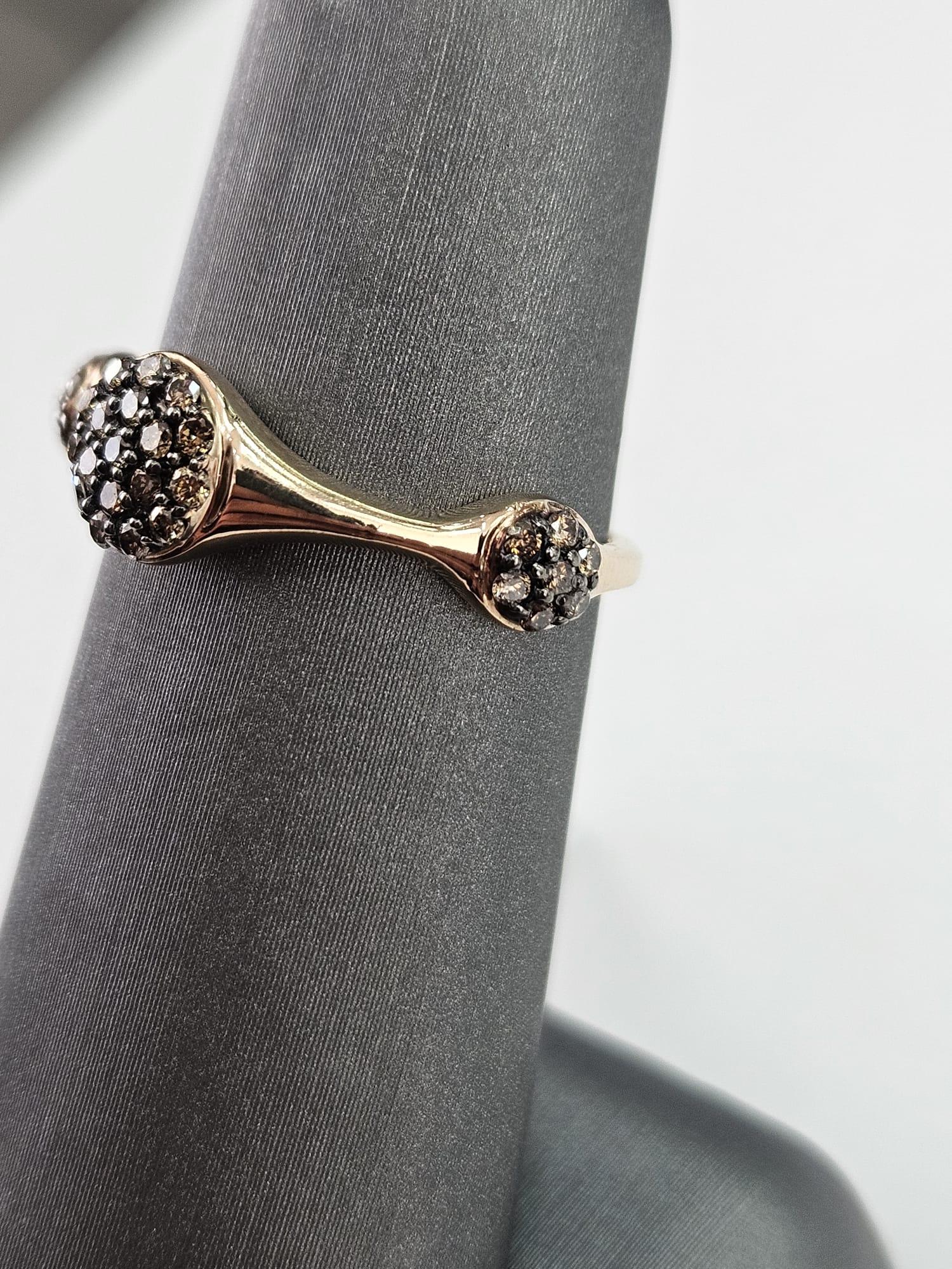 Introducing a striking Brown Diamond cluster ring, a unique and captivating piece that exudes warmth and elegance. With a total carat weight of 0.31 carats, this ring features three horizontally oriented oval-like shapes, each filled with lustrous