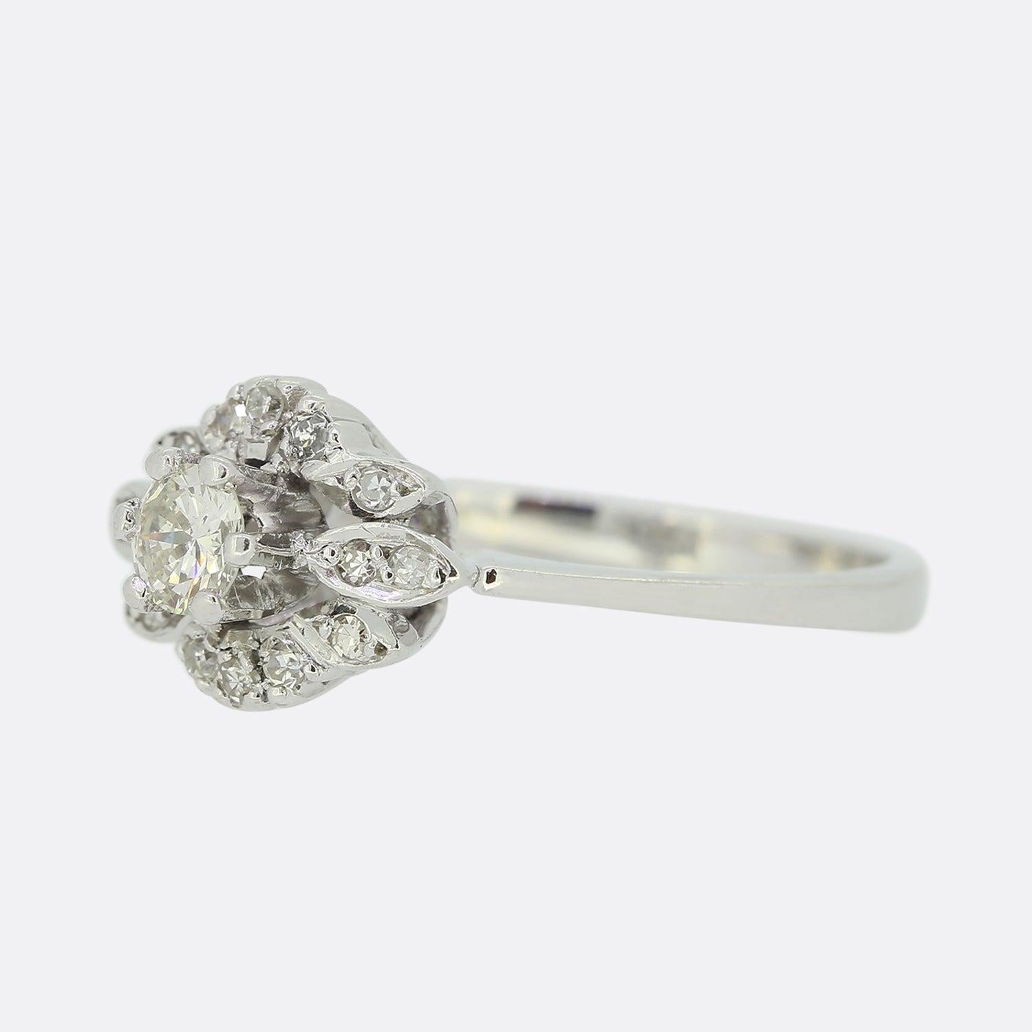 Dies ist eine schöne 18ct Weißgold Diamant-Cluster-Ring. Der runde Brillant im Zentrum dieses Schmuckstücks hat eine blumenähnliche Struktur mit mehreren in Krallen gefassten Diamanten im Einzelschliff, die am äußeren Rand in blütenblattförmigen