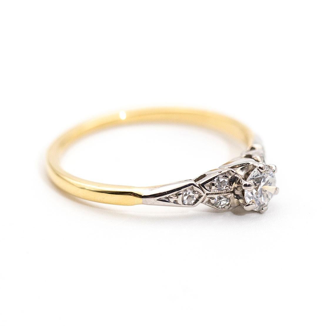 Lovingly crafted in 18 carat yellow and white gold is this darling vintage ring flaunting a central 0.32 carat round brilliant cut diamond flanked by smaller round diamonds in the band. We have named this vintage splendour The Camille Ring. The