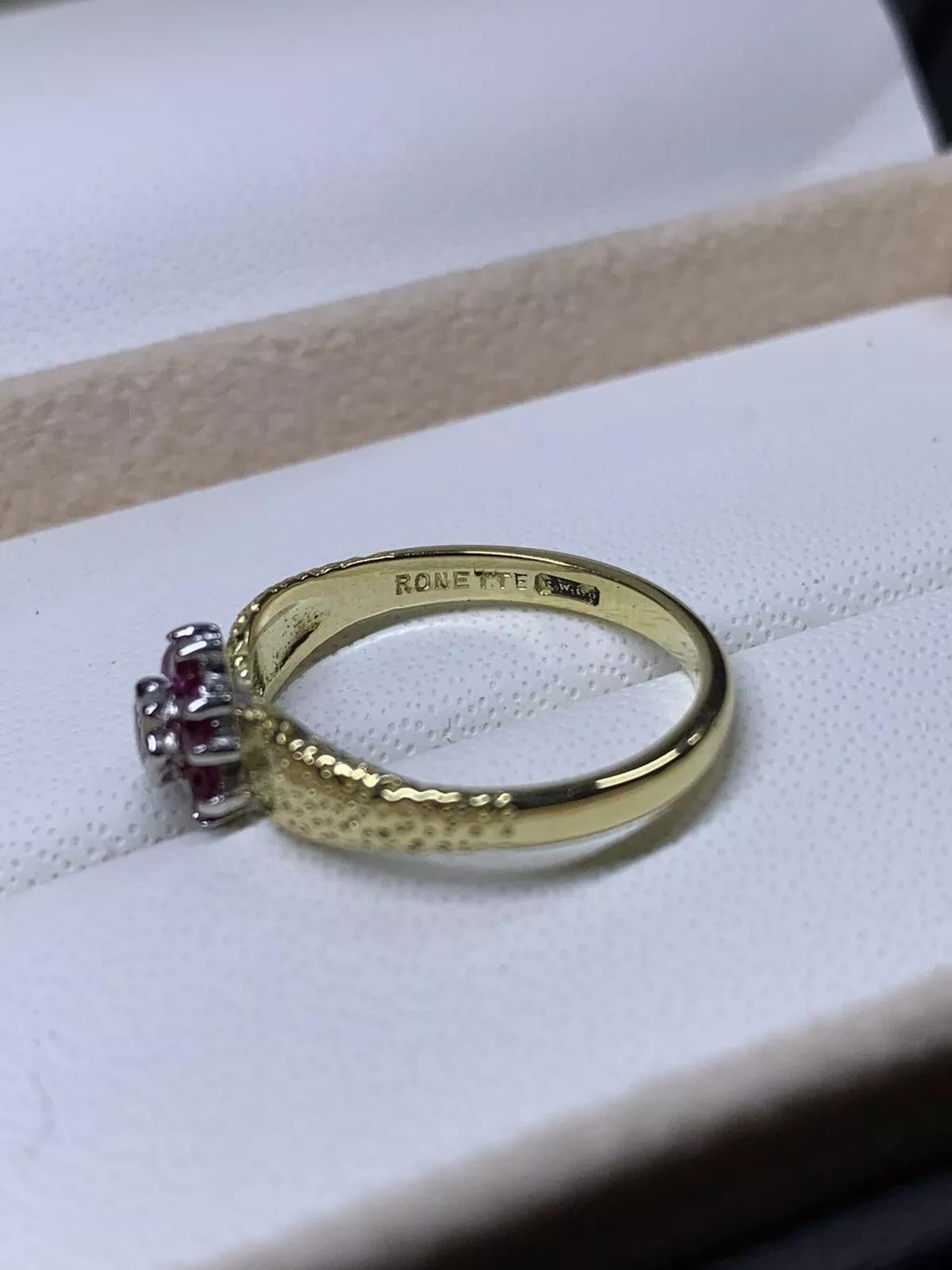 Cette superbe bague de fiançailles vintage de Ronette Antique ne manquera pas d'attirer votre attention. Avec un magnifique rubis de 0,32ct comme pierre principale, entouré de diamants étincelants, cette bague est un véritable coup de cœur.