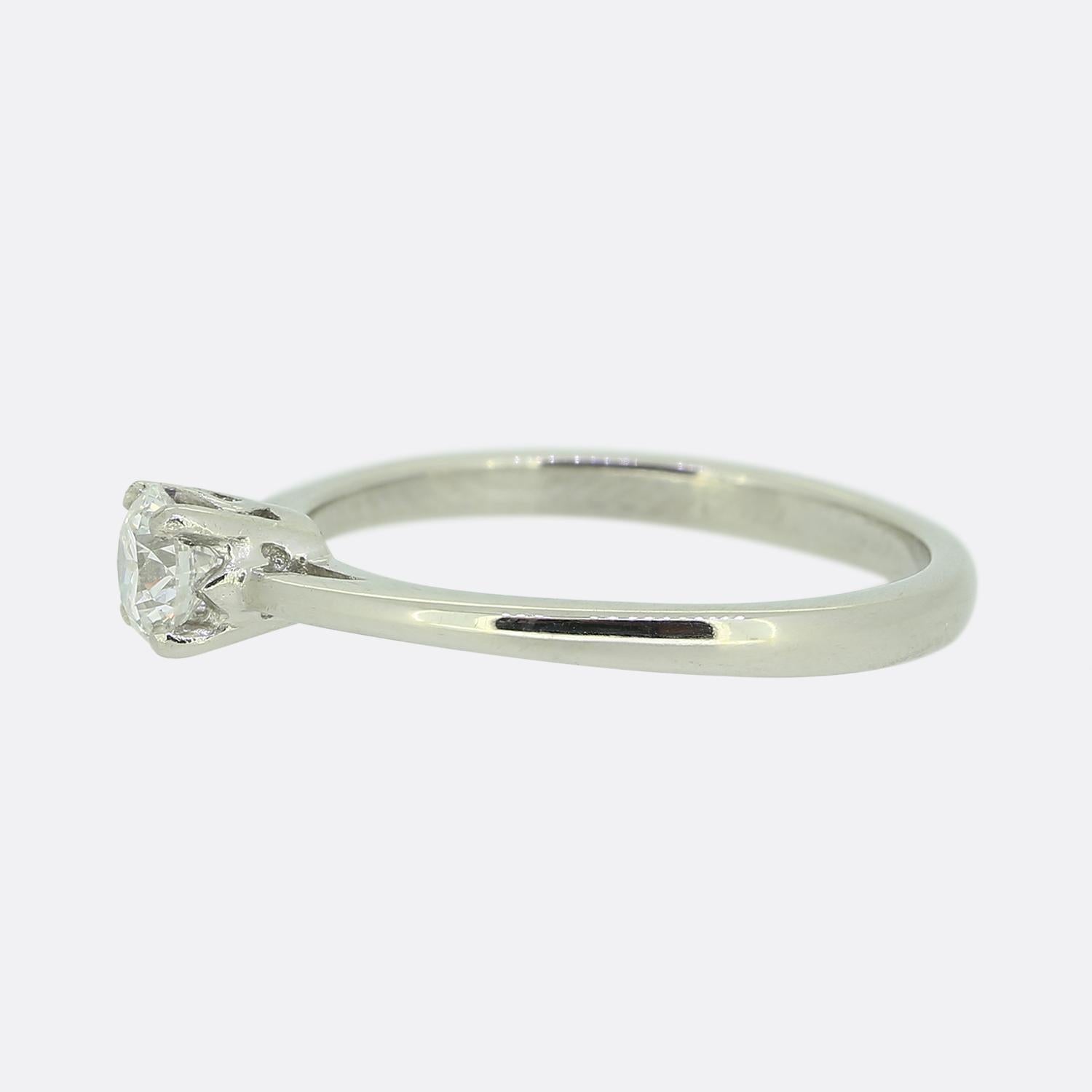Aquí tenemos un anillo de compromiso de una sola piedra de estilo clásico. El punto focal de esta pieza es un diamante redondo de talla brillante de 0,33 quilates que se asienta solitario y orgulloso en un engaste de cuatro garras sobre una banda de