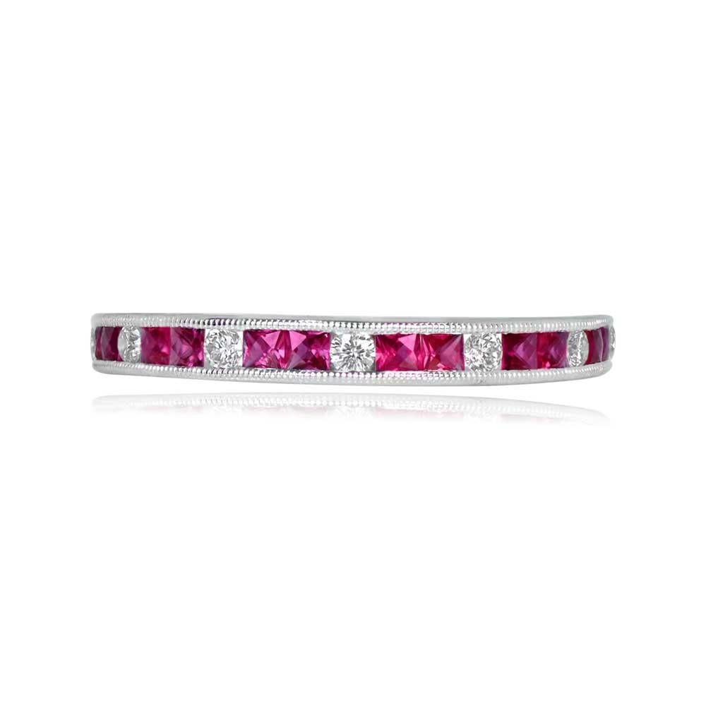 A platinum half-eternity wedding band featuring round brilliant cut diamonds set between French-cut natural rubies. With a width of 2.6mm, the total ruby weight is 0.33 carats, and the total diamond weight is 0.14 carats. The gemstones are