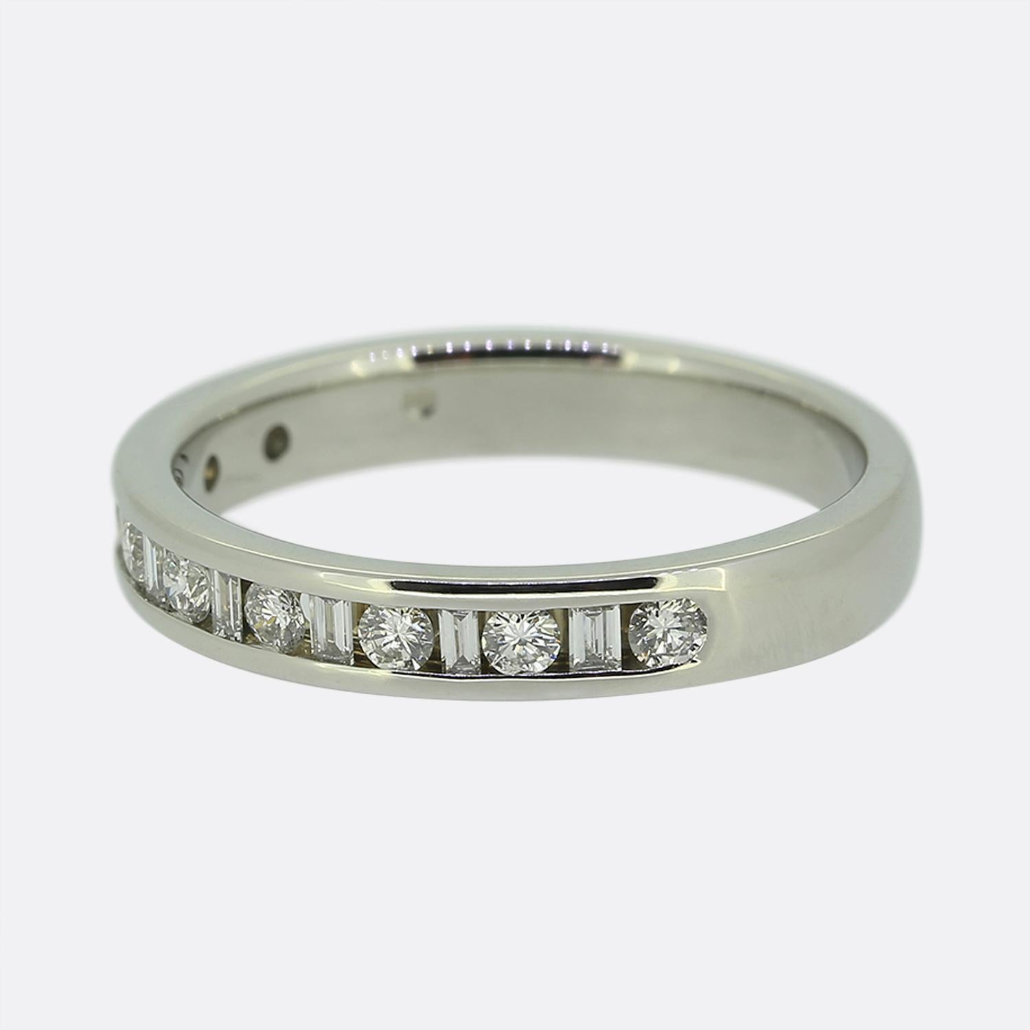 Hier haben wir einen klassisch gestylten Ring mit halbem Ewigkeitsring. Das aus Platin gefertigte Schmuckstück zeigt eine abwechselnde Abfolge von strahlend weißen, geraden Diamanten im Baguette- und runden Brillantschliff, die alle in einer