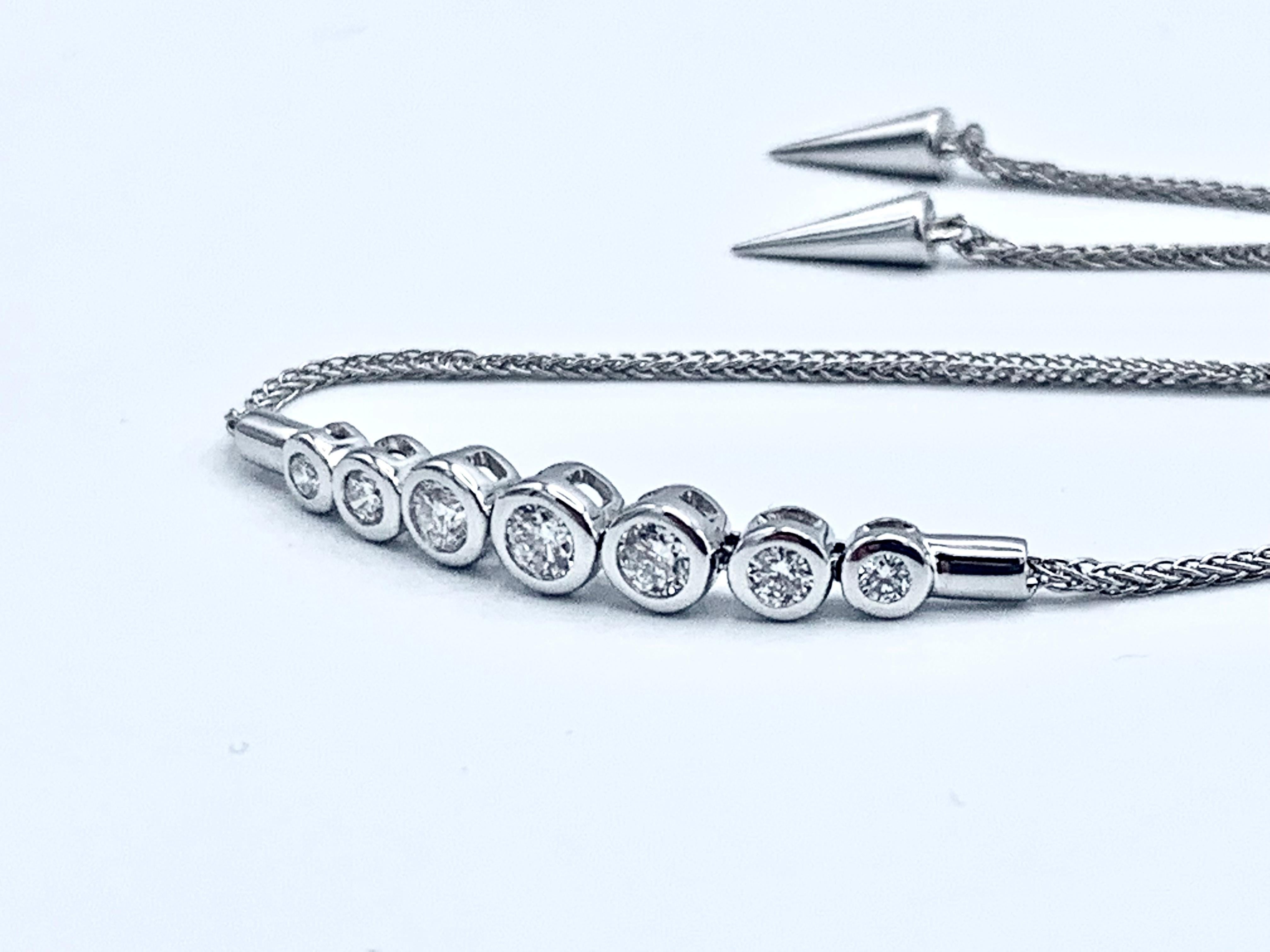 This beautiful bracelet consists of 14 karat white gold and 7 round SI1 G-H diamonds totaling 0.34 carats. These bezel set diamonds graduate towards the center. The bracelet is finished by a 14 karat white gold wheat chain that is adjustable like a