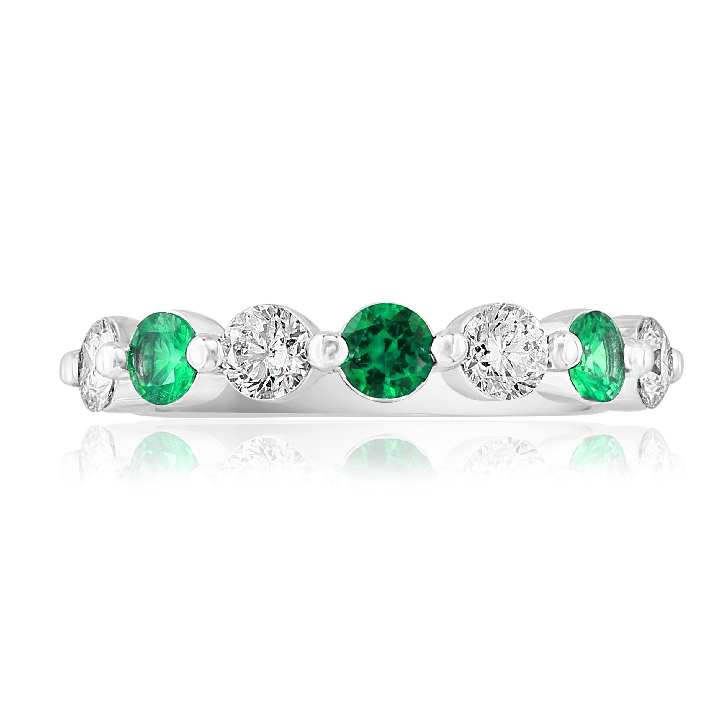 A fashionable and classic wedding band showcasing 4 brilliant cut diamonds weighing 0.62 carats total alternating with 3 round emeralds weighing 0.35 carats. Stones secured with a shared prong setting made with 14K white gold. A versatile piece that