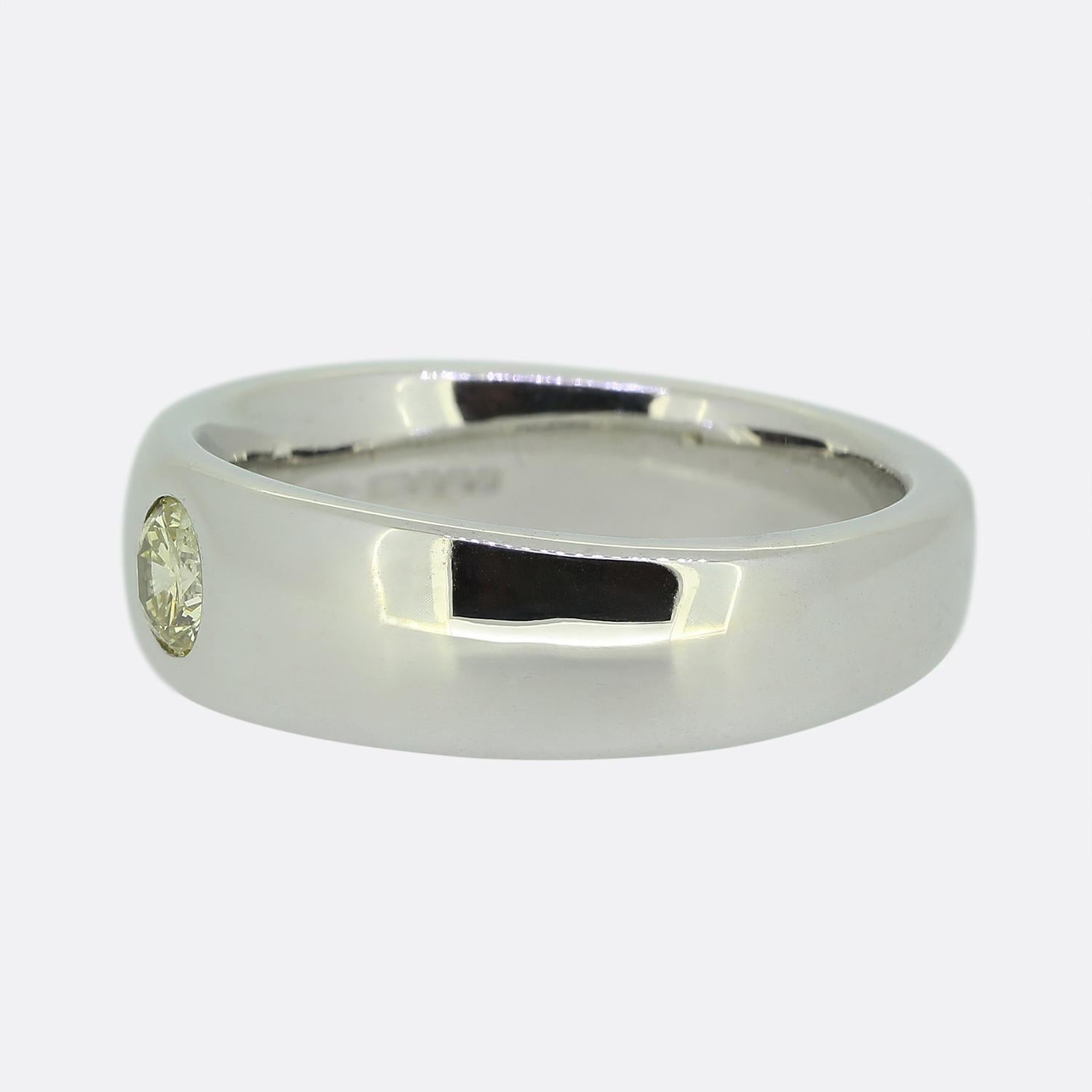 Nous avons ici une bague pour homme à un seul diamant, élégante et raffinée. Réalisée en or blanc 18 carats, cette pièce contemporaine est ornée d'un seul diamant rond de 0,35 carat de taille brillant, serti à fleur de la bande. Le design est