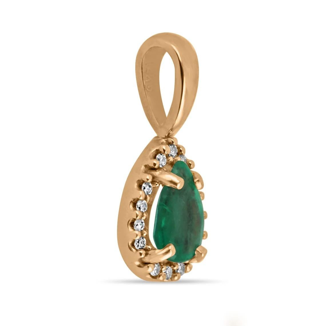 A stunning emerald and diamond pendant. This lovely piece showcases a petite 0.30-carat, natural Zambian emerald with a gorgeous medium yellowish-green color, and great characteristics. Securely prong-set; surrounding this gem is a halo of petite