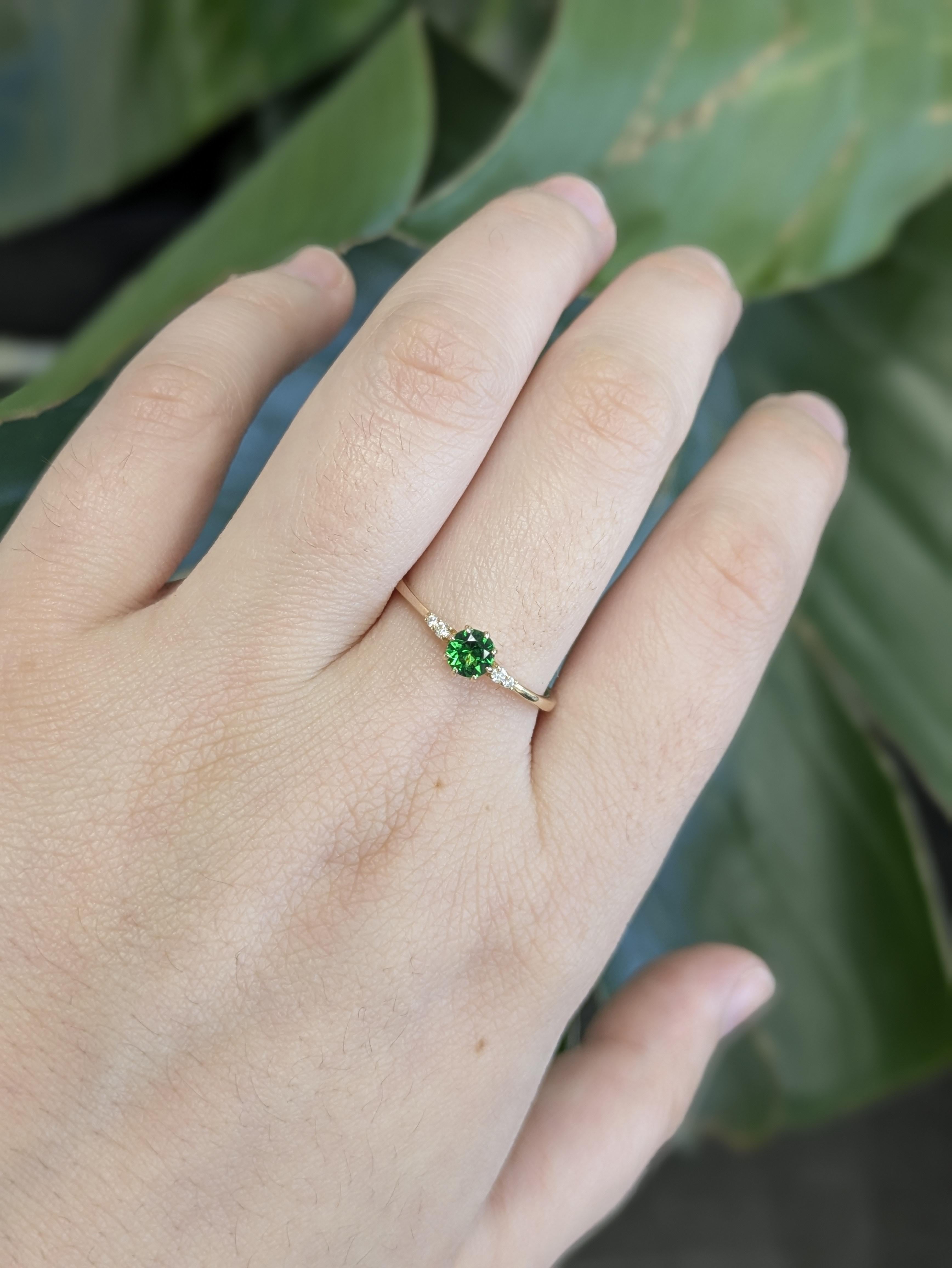 Este elegante anillo incluye un raro granate Tsavorita redondo de 0,37 ct, apreciado por su vivo tono verde y su excepcional brillo. Extraída en Tanzania y de 4 mm, la piedra central está acentuada por cuatro brillantes diamantes que suman 0,04 ctw.