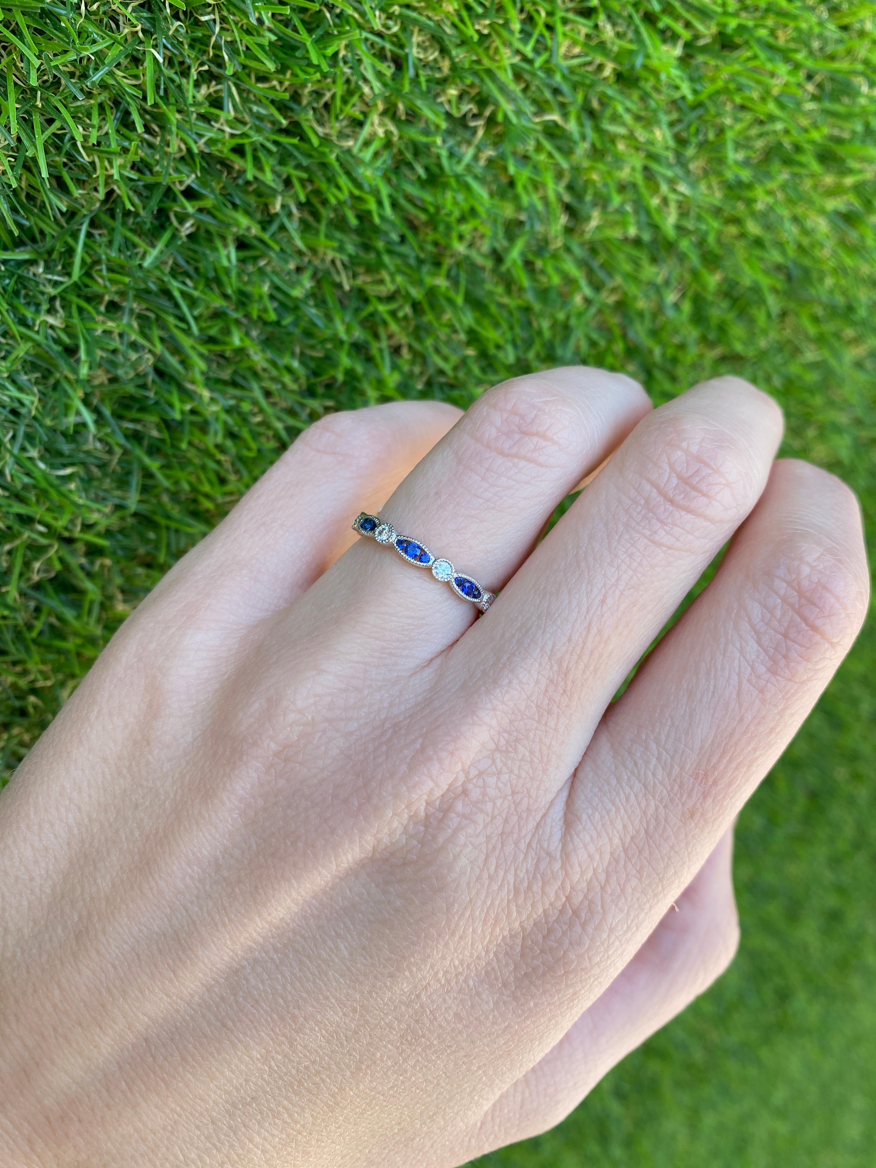 This is the perfect and unique stacking band! It features 0.37 carat total weight in round blue sapphires set in a marquis like shape alternating with 0.17 carat total weight in round diamonds. It is set in 18 karat white gold with milgrain