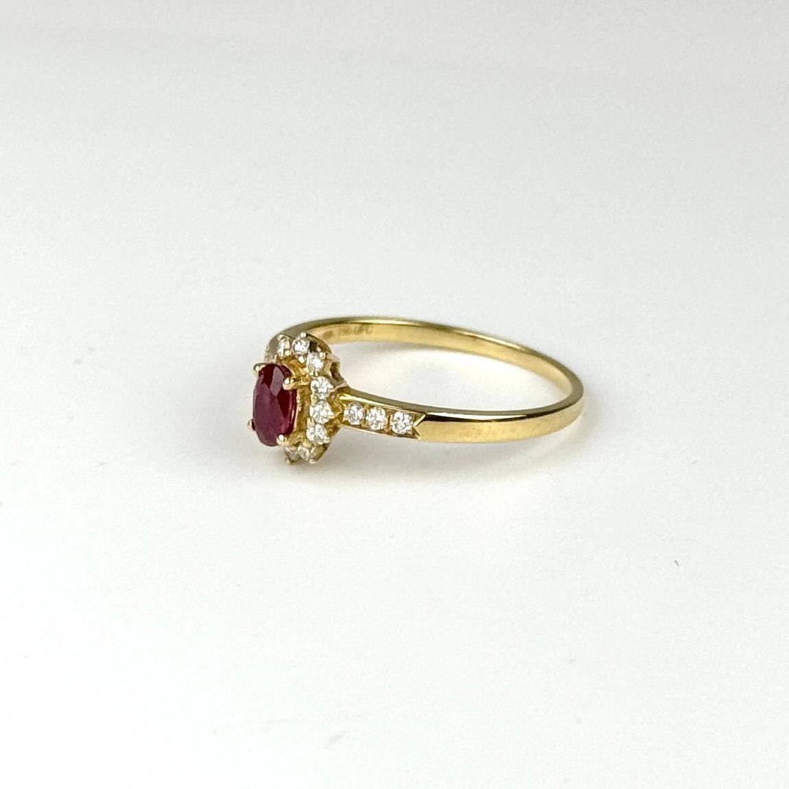 Questo squisito anello presenta un rubino del Mozambico da 0,38 carati, noto per il suo colore vibrante e la sua brillantezza. Il rubino è elegantemente incastonato in un'aureola di diamanti, per un totale di 0,17 carati, con un colore G-H e una