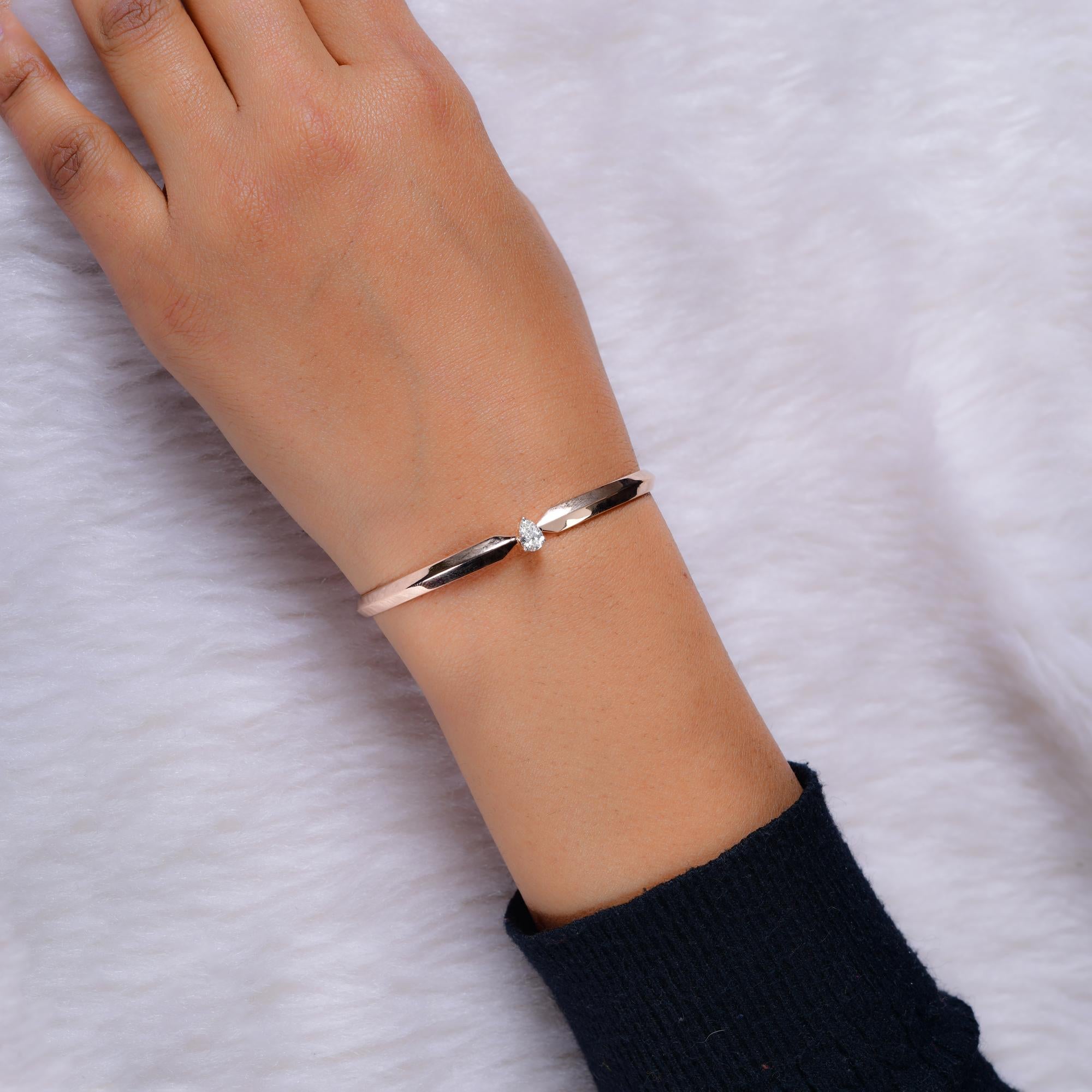 Questo braccialetto Clamper in oro rosa 14 carati con diamante solitario a pera da 0,38 carati presenta un solitario con taglio a pera incastonato al centro del braccialetto.
I diamanti sono un simbolo universale di eternità e forza. È una pietra di