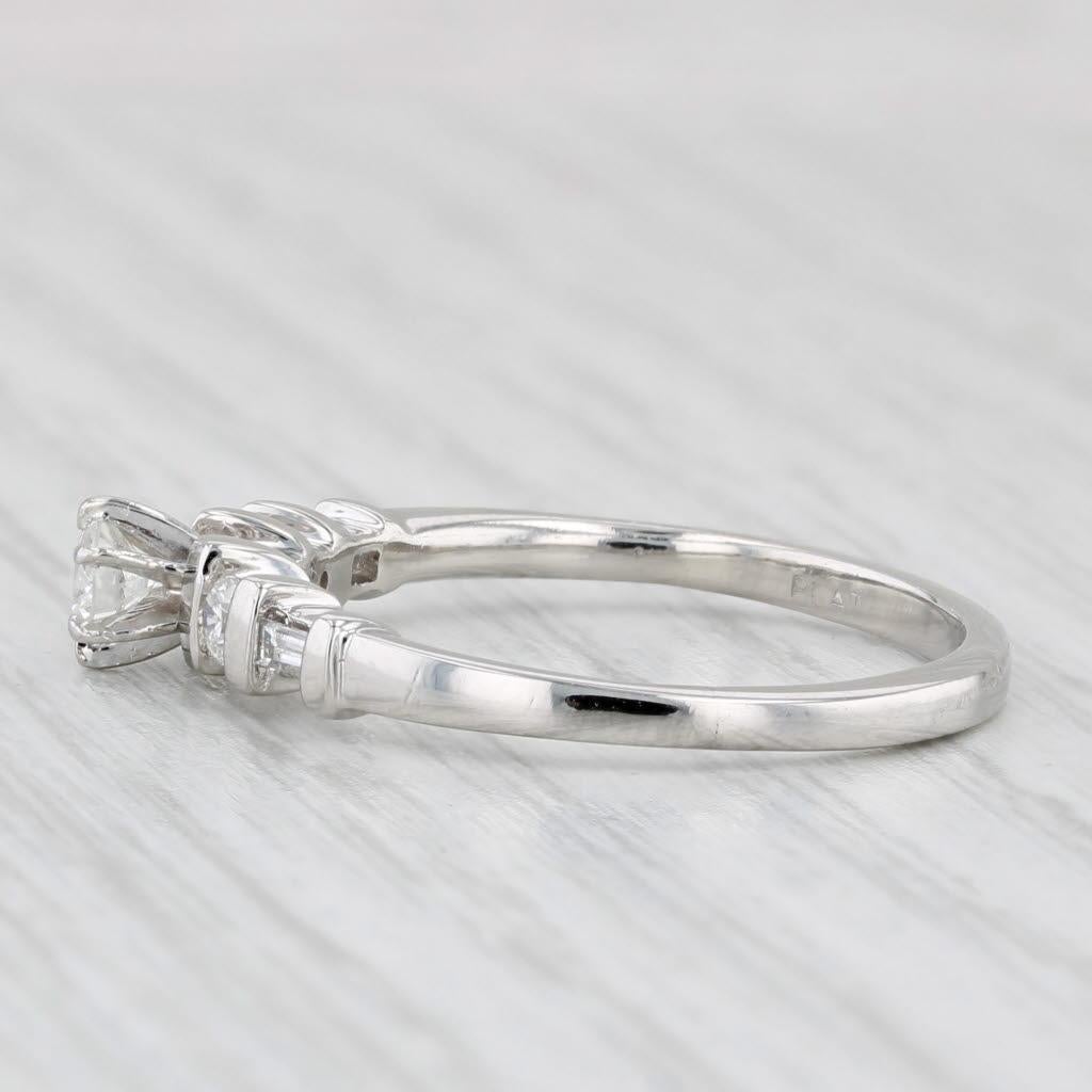 Gemstone Information:
- Natural Diamond (center) -
Carats - 0.19ct 
Cut - Round Brilliant
Color - H
Clarity - I1 

- Natural Diamonds -
Total Carats - 0.19ctw
Cut - Round Brilliant & Baguette
Color - G - I
Clarity - VS2 - I1

Metal: Platinum
Weight: