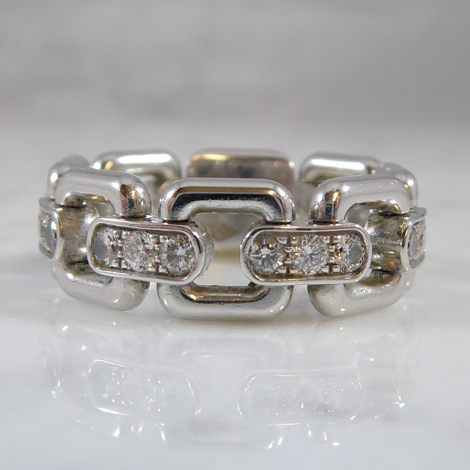 No longer in production, this diamond set designer ring is a flexible, chain-like band.  Comprising of a white panel, engraved 