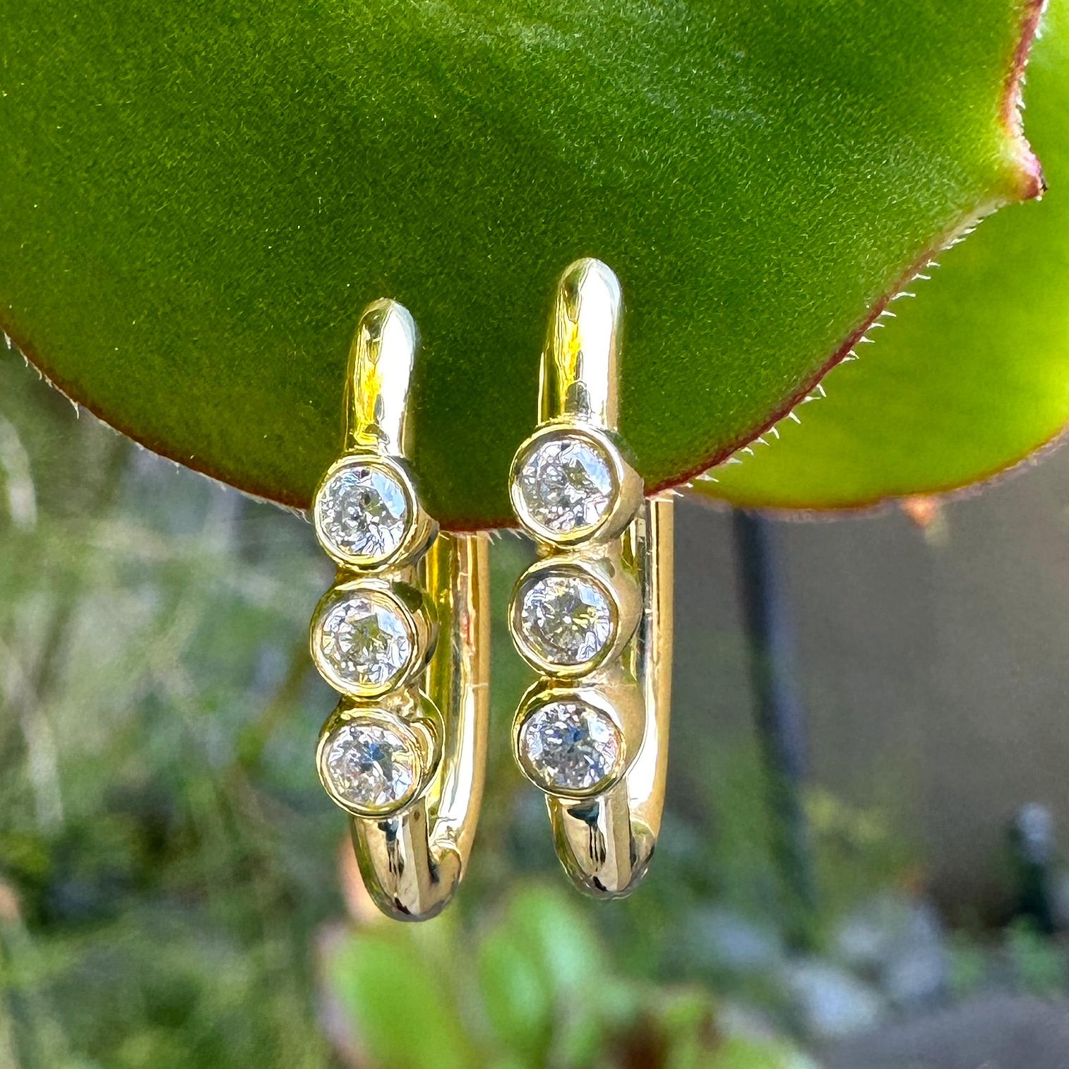 Our most popular hoop is a huggie-style hinged oval with three bezel-set stones in the front -- a design that hits the sweet spot between comfortable and luxe.  

For the pair listed here, Eytan used 18 karat yellow gold and set the bezels with