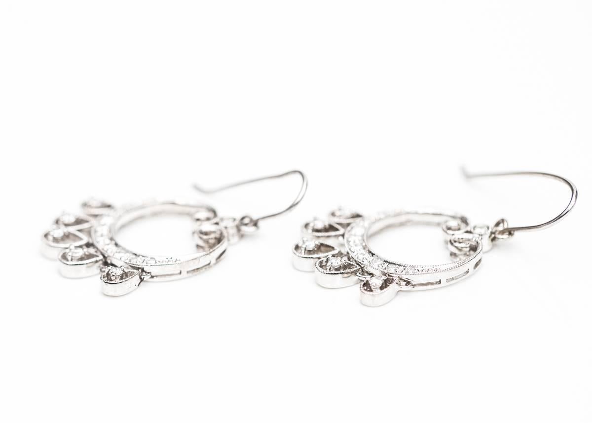 Diamond Chandelier Earrings in 14 Karat White Gold 

Each earring features a Graceful, Diamond Encrusted White Gold Circle with 5 Pear-shaped White Gold and Diamond charms. Each Charm holds a Round Brilliant Diamond in a tear drop shaped frame. 5