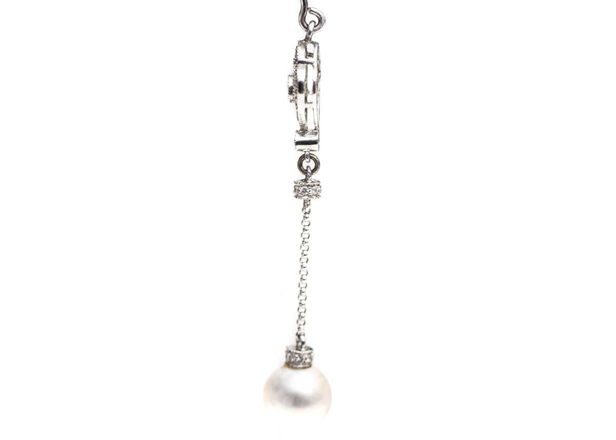 8 millimeter Pearl, Round Brilliant Diamond and 14 Karat White Gold Drop Earrings

Each 6 centimeter long earring features a Diamond-capped, 8 millimeter white Pearl. 
At the top of each earring is a Round Brilliant Diamond in a Diamond encrusted,