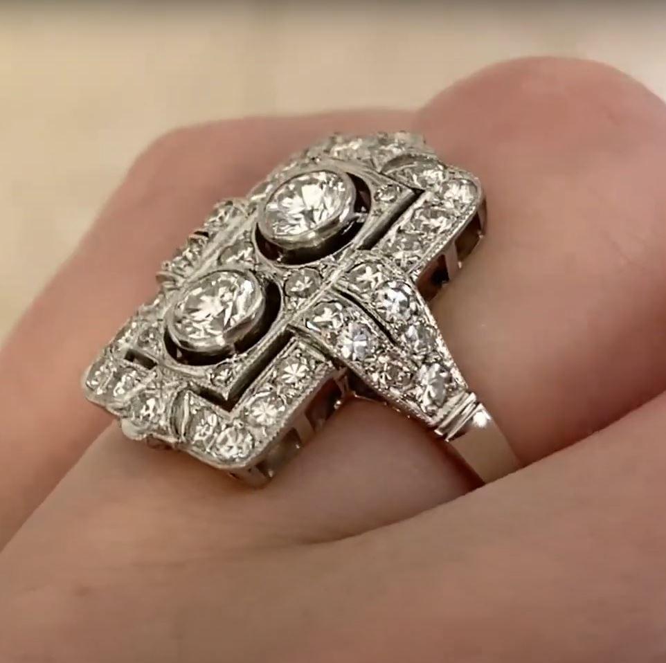 This exquisite platinum ring showcases two bezel-set round brilliant-cut diamonds at its center, totaling approximately 0.4-carats. These diamonds, elegantly positioned in a north-south orientation, possess an I color grade and VS2-SI1 clarity,