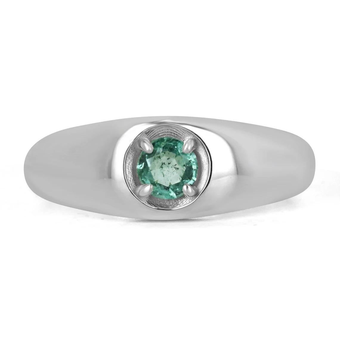 A lovely solitaire emerald ring; featuring a petite under half a carat round cut emerald from the origin of Zambia. The gemstone showcases a gorgeous medium green color with excellent clarity and luster. Set in a secure four-prong setting, crafted