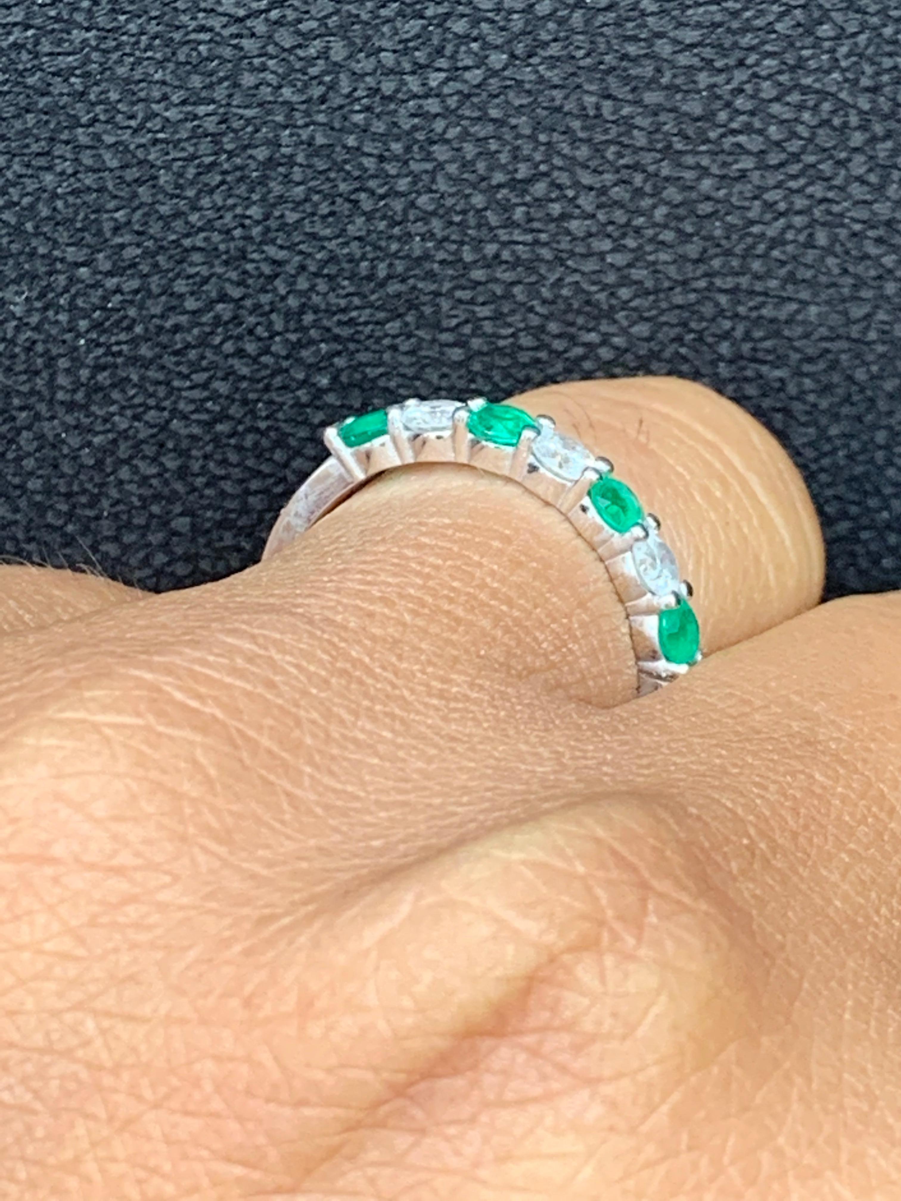 A fashionable and classic wedding band showcasing 4 color-rich green emeralds weighing 0.43 carats total that alternate with 3 brilliant round diamonds weighing 0.37 carats total. Stones secured with a shared prong setting made with 14 karats white