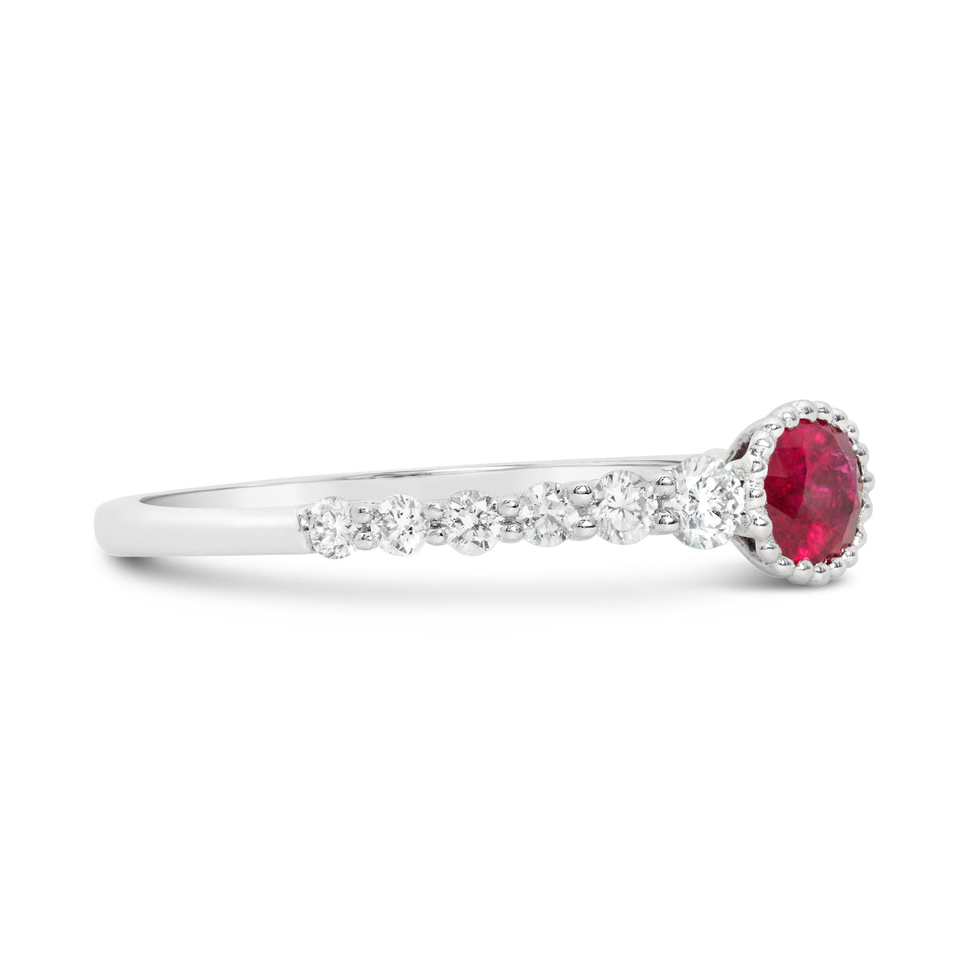 A simple fashion ring, featuring a 0.43 carat oval cut ruby, set on a beaded bezel. Accented by 12 graduating round brilliant cut diamonds weighing 0.33 carat total. Made with an 18K white gold mounting. Size 6.5 US, resizable upon request. 

Roman