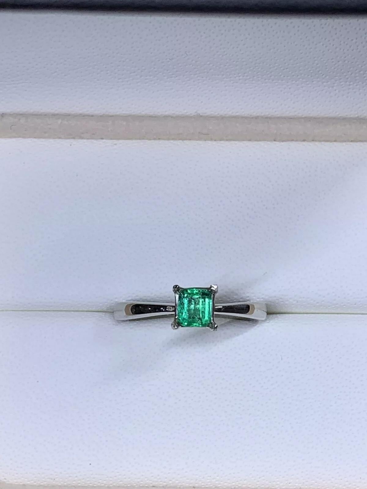 This exquisite 0.43ct green emerald solitaire engagement ring in 18ct white gold is the perfect symbol of love. The stunning emerald stone is set in a classic solitaire style, showcasing its natural beauty and elegance. With a ring size of M and a