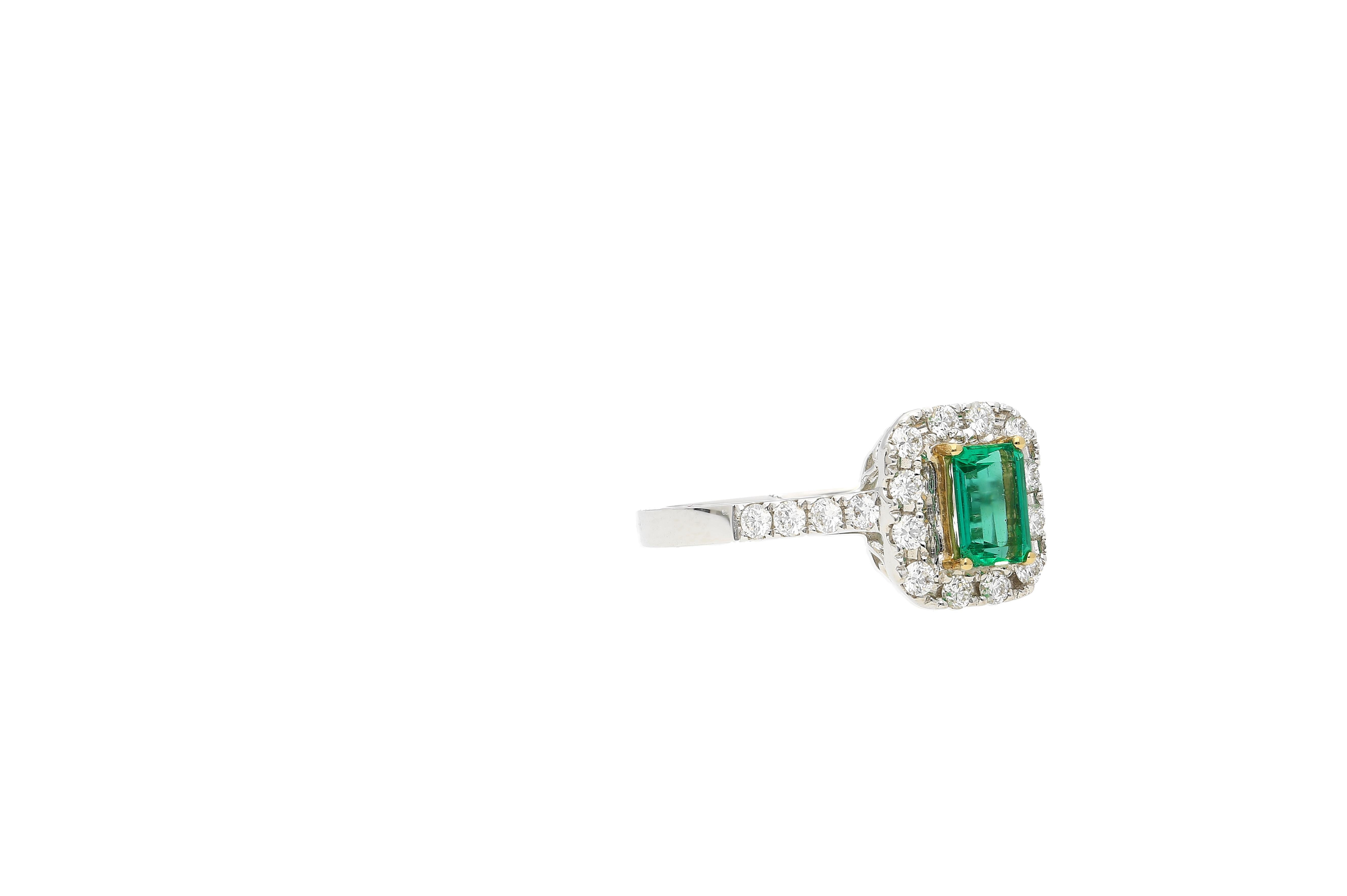 Natural Colombian Emerald of 0.44 carats. Center stone Emerald is surrounded by 20 eye-clean colorless diamonds of 0.35 carats (total). The  Emerald is well contrasted by the yellow gold 4-prong mounting. 

This ring has the structural versatility
