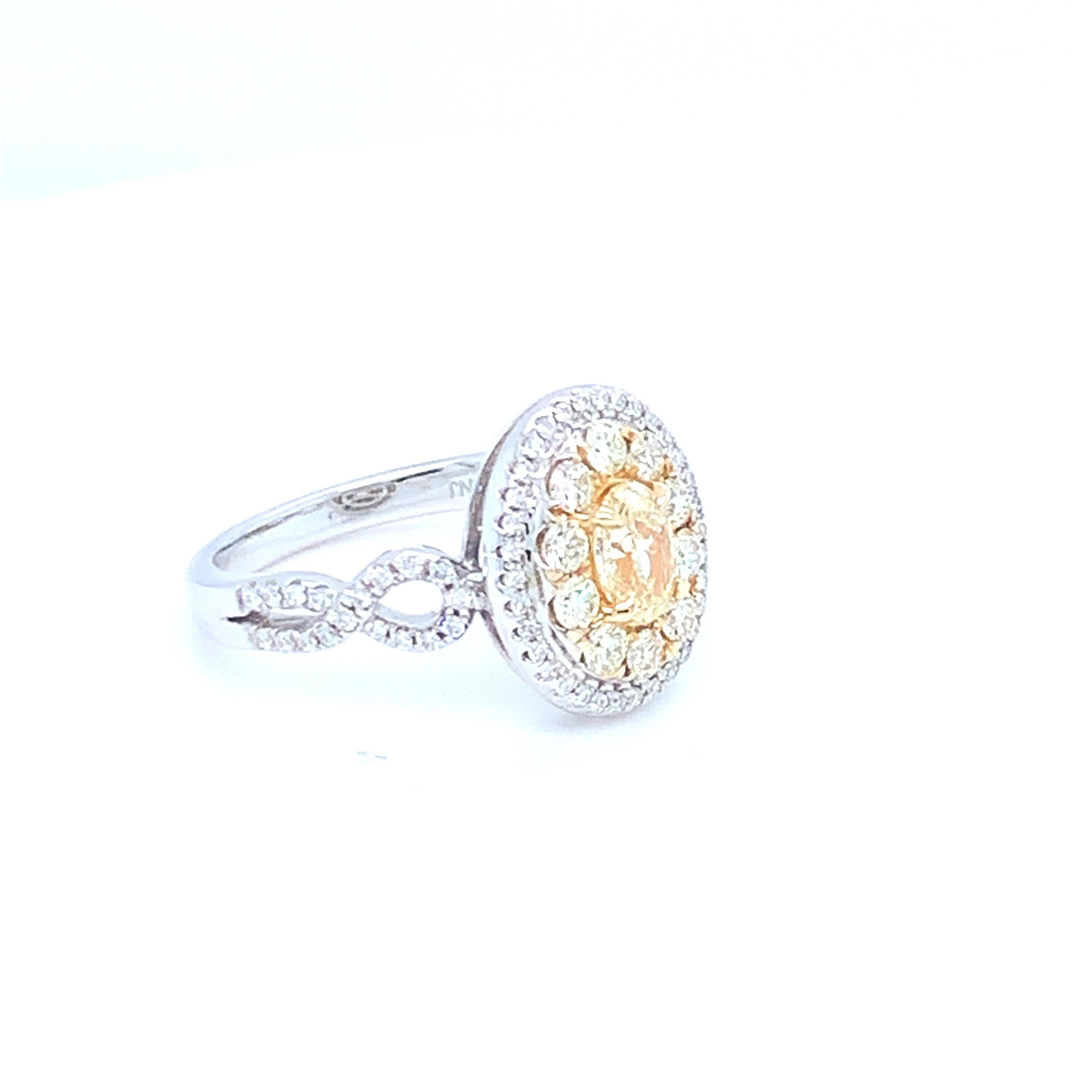 Este precioso anillo con halo presenta un diamante ovalado amarillo en el centro. Engarzada en oro de dos tonos para hacer juego con los engastes de diamantes de dos tonos. Esta pieza se ha elaborado a mano para conseguir la mejor calidad. 
Diamante