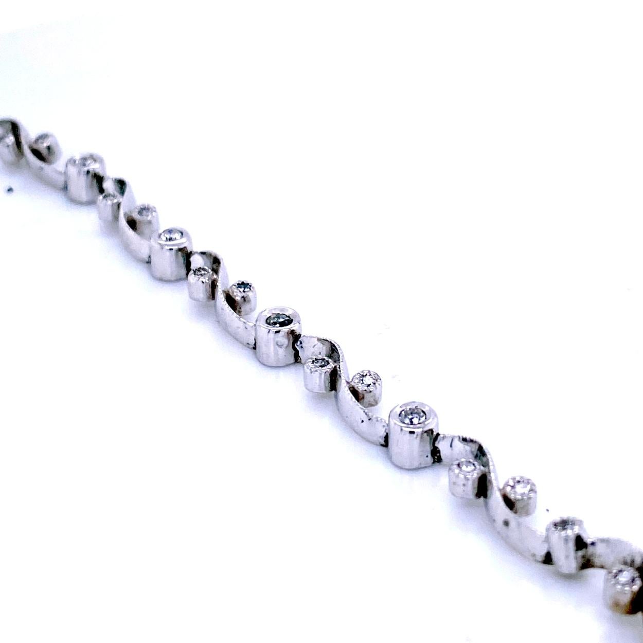 This Diamond Bracelet consists of 11 Links Bezel Set 1.2 mm Round Brilliant diamonds and 5 Bezel Set 1.8 mm Round Brilliant diamonds centrally located set in between the links to present an impressive look. The bracelet is made in 18K Gold with