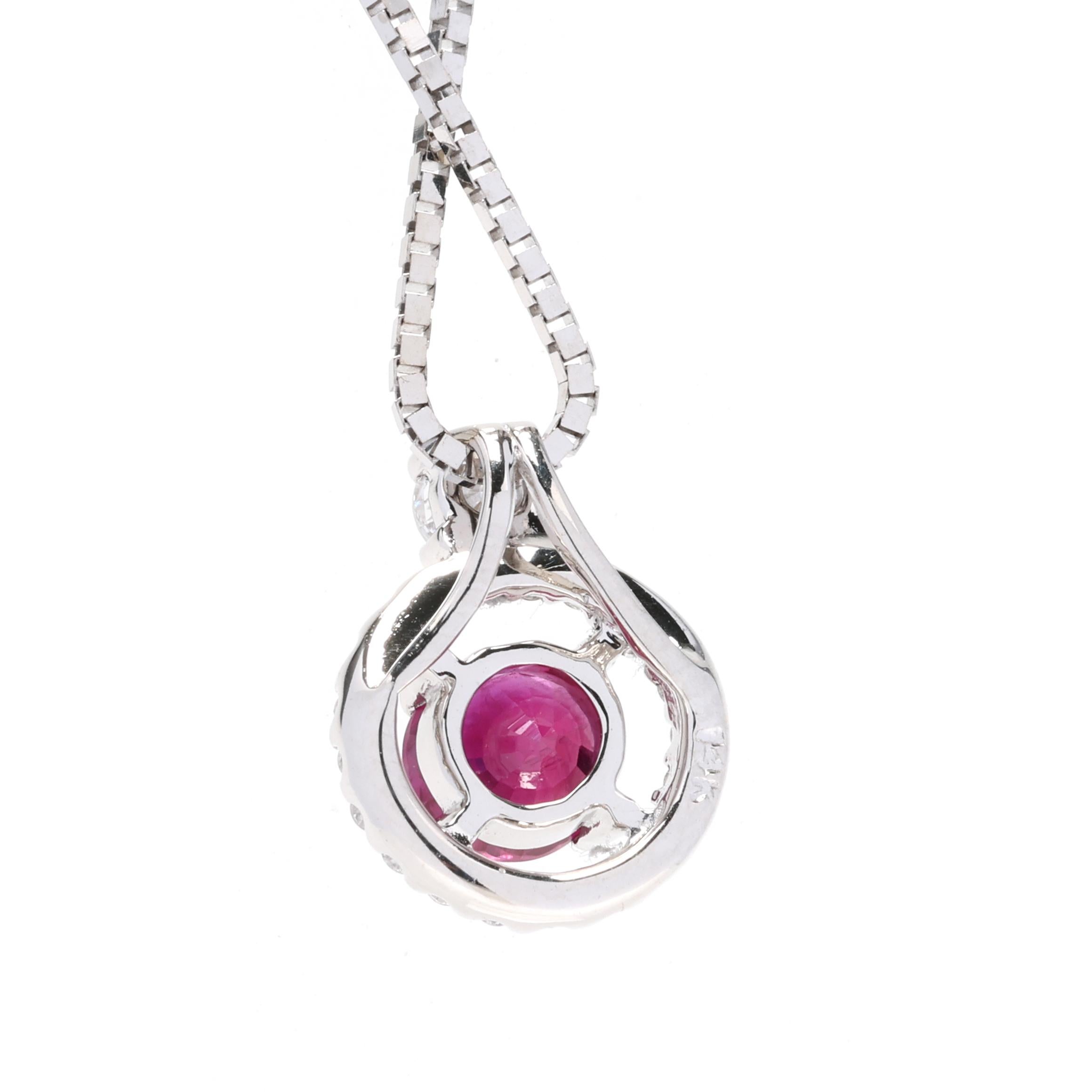 This stunning pendant necklace features a vibrant 0.47 carat total weight ruby gemstone surrounded by sparkling diamond accents. The pendant is crafted in 14k white gold and hangs on a 20-inch chain. The ruby is a rich red color and is beautifully