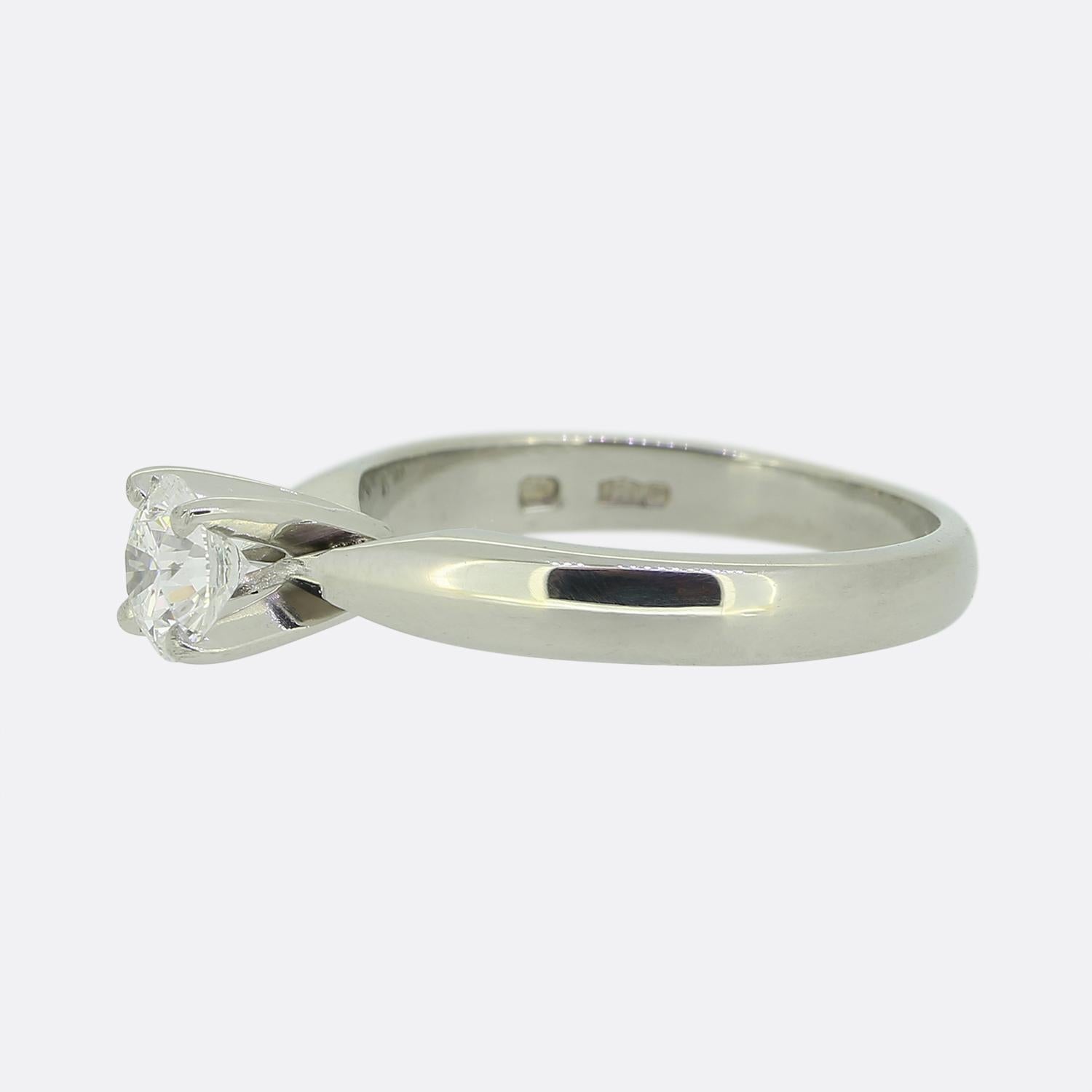 Aquí tenemos un anillo de compromiso solitario de diamantes en platino. Un único diamante redondo de talla brillante de 0,48 quilates se asienta solitario y orgulloso en el centro de la cara en un engaste de cuatro garras sobre una banda de platino