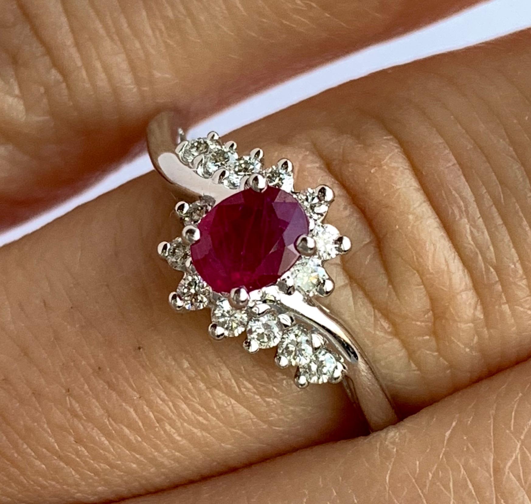 Material: 14k White Gold 
Center Stone Details: 0.48 Carat Oval Ruby measuring 5x4 mm
Mounting Diamond Details: 20 Brilliant Round White Diamonds at 0.20 Carats - Clarity: SI / Color: H-I
Ring Size: Size 6.5. Alberto offers complimentary sizing on