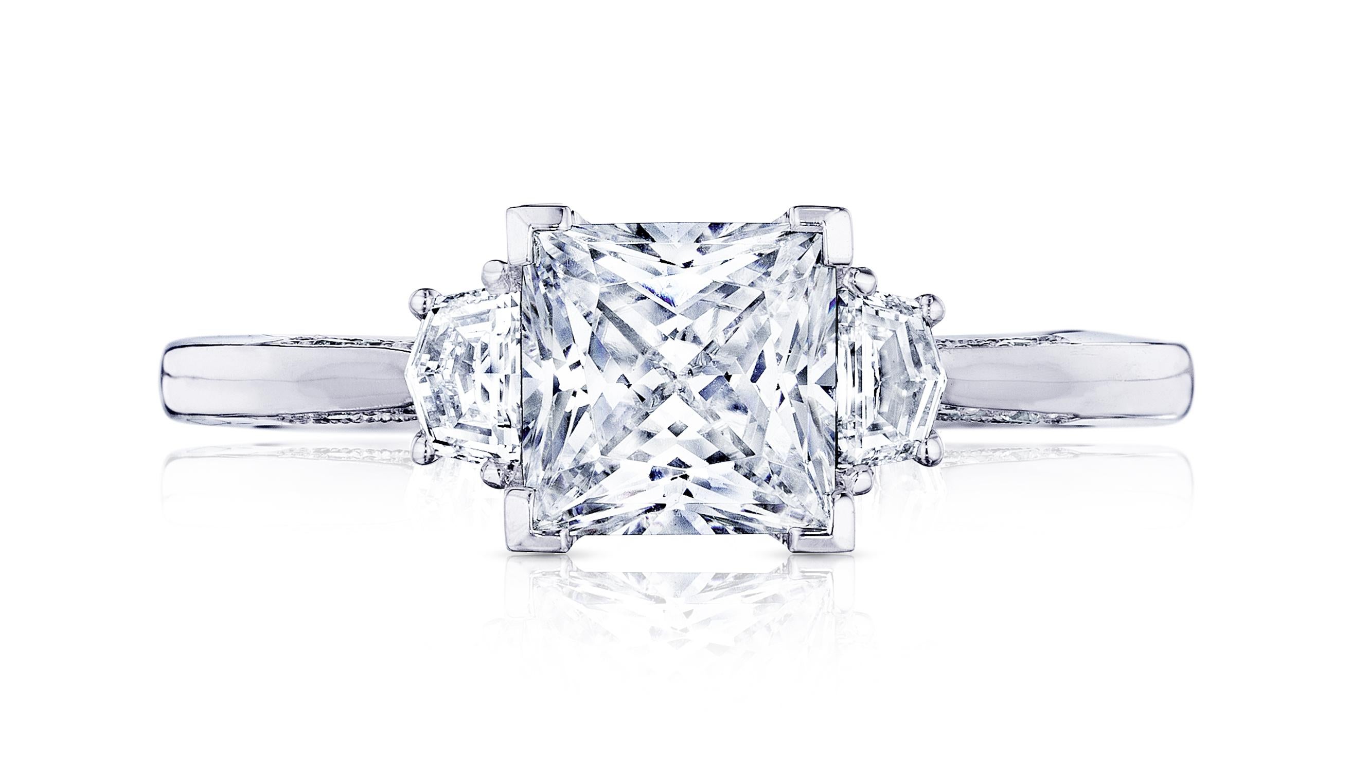 An exceptional engagement ring and sparkling precious jewel, features a asscher brilliant diamond center stone, given prominence by two tapered trapezoid side stones on a delicate platinum band. The delicate details of this refined diamond jewelry