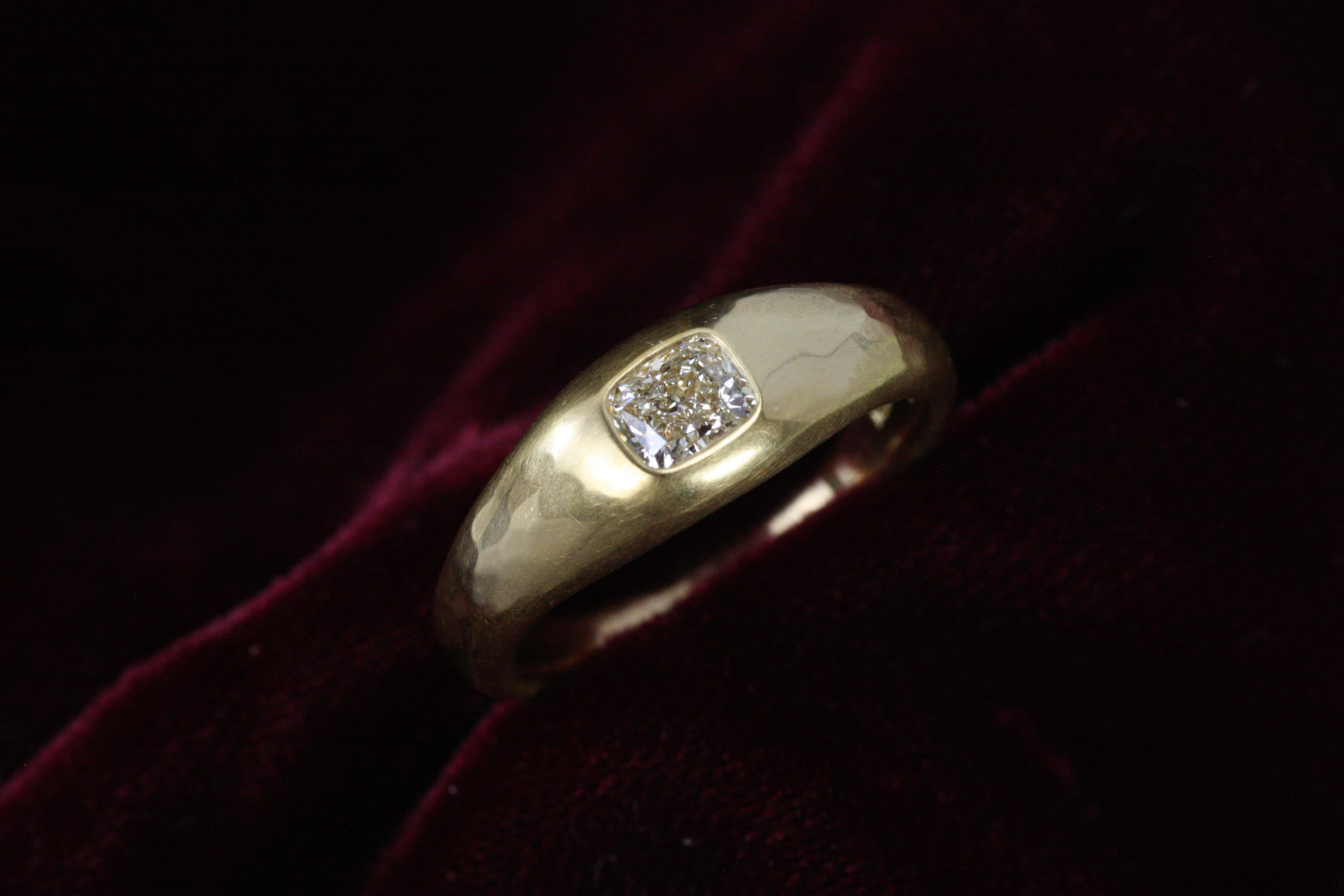 This gypsy ring redefines elegance with a 0.50ct cushion cut diamond nestled in a low-profile, flush setting. Crafted in 22K yellow gold with a matte hammered finish, its minimalist design pairs sophistication with everyday practicality and comfort.