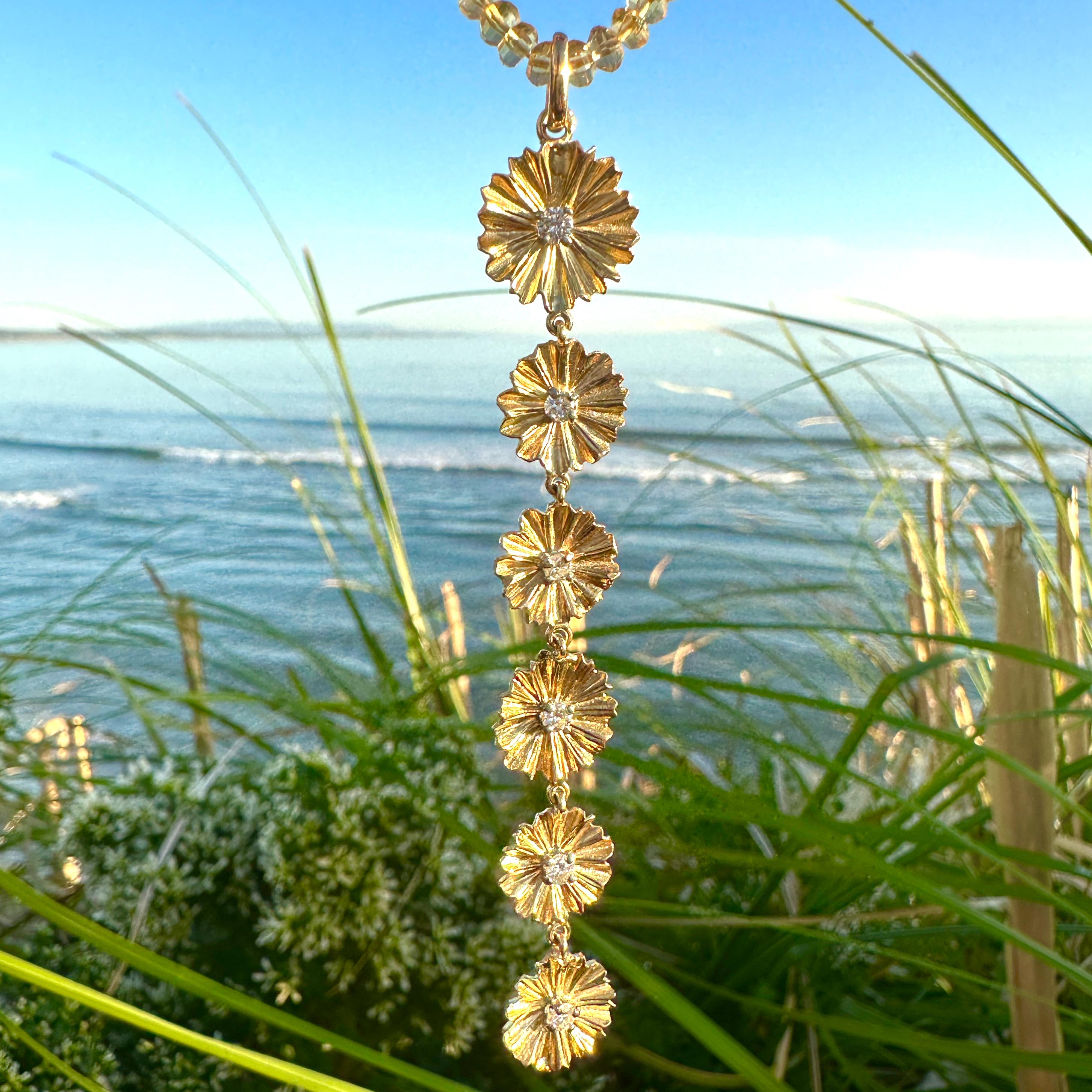 This sexy, playful pendant by Eytan Brandes features six daisy links in vivid 18 karat yellow gold, each centered with a bright and clean white diamond.  

The six diamonds range in size from 0.07 to 0.12 carats for a total diamond weight of 0.50
